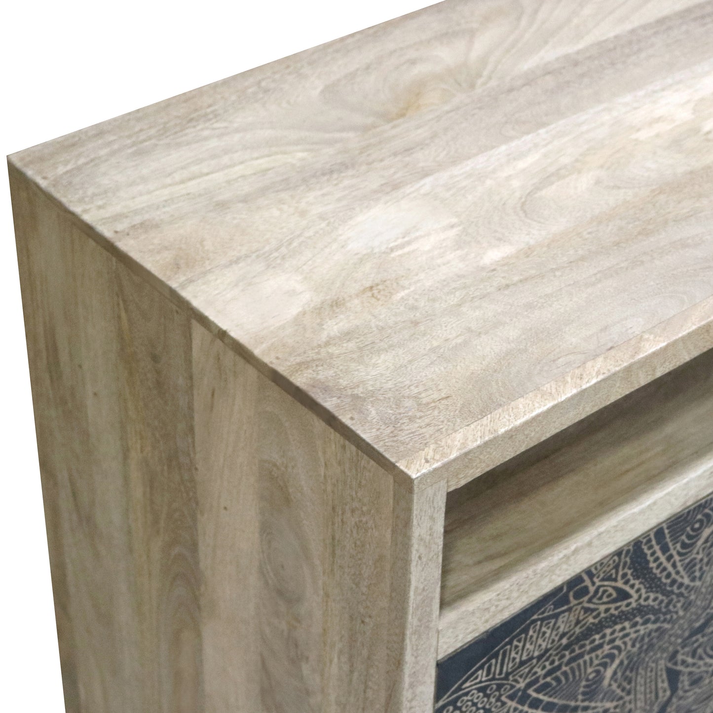 Right angled close-up tabletop/corner detail view of a farmhouse natural and black two-door accent cabinet with medallion designs on a white background