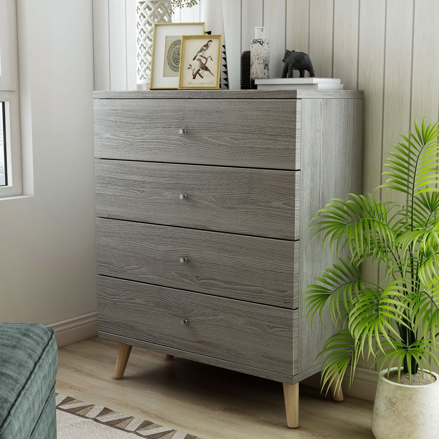Left angled mid-century modern distressed gray four-drawer chest dresser in a living area with accessories