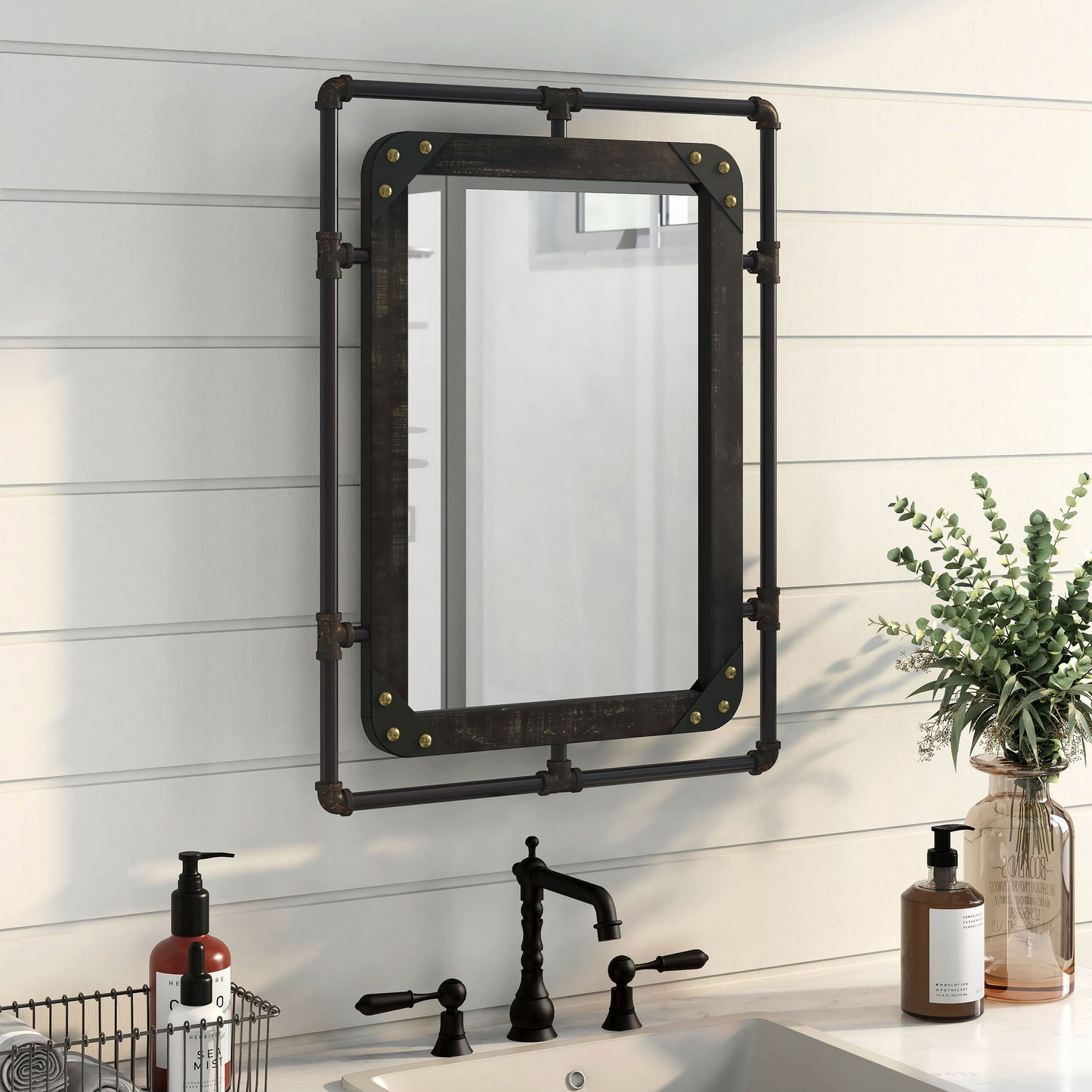 Right angled industrial reclaimed black oak and water pipe wall mirror over a vanity with accessories