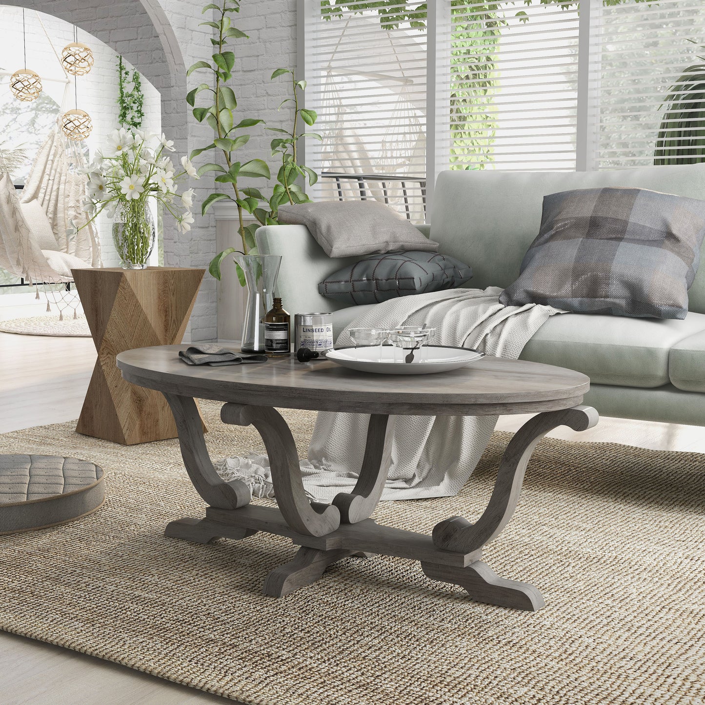 Left angled farmhouse vintage gray oak curved pedestal coffee table in a living room with accessories