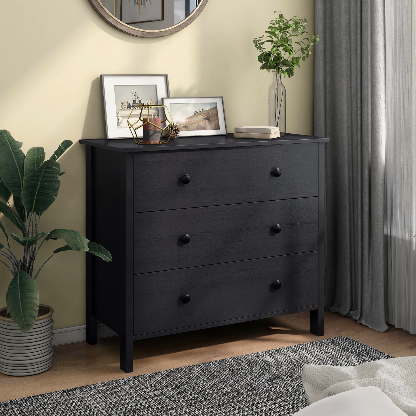Left angled transitional black three-drawer youth dresser in a bedroom with accessories