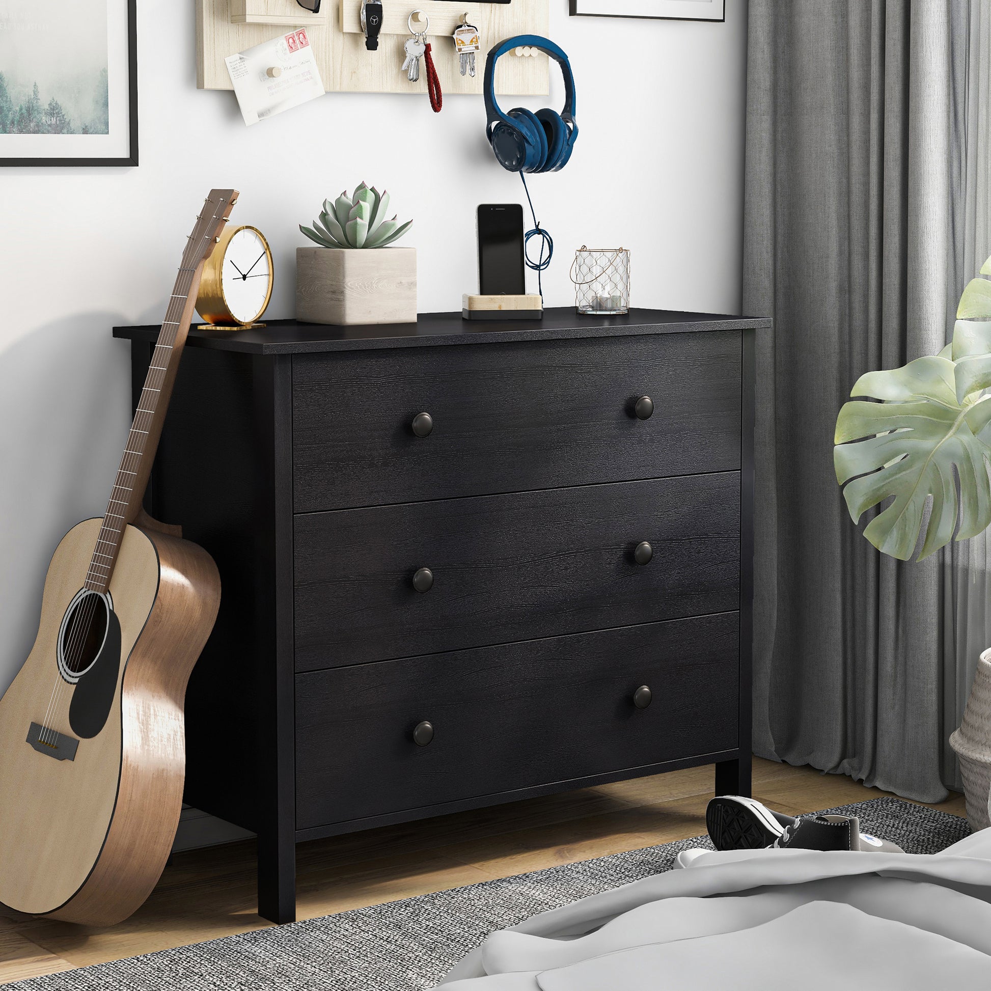 Right angled transitional black three-drawer youth dresser in a bedroom with accessories