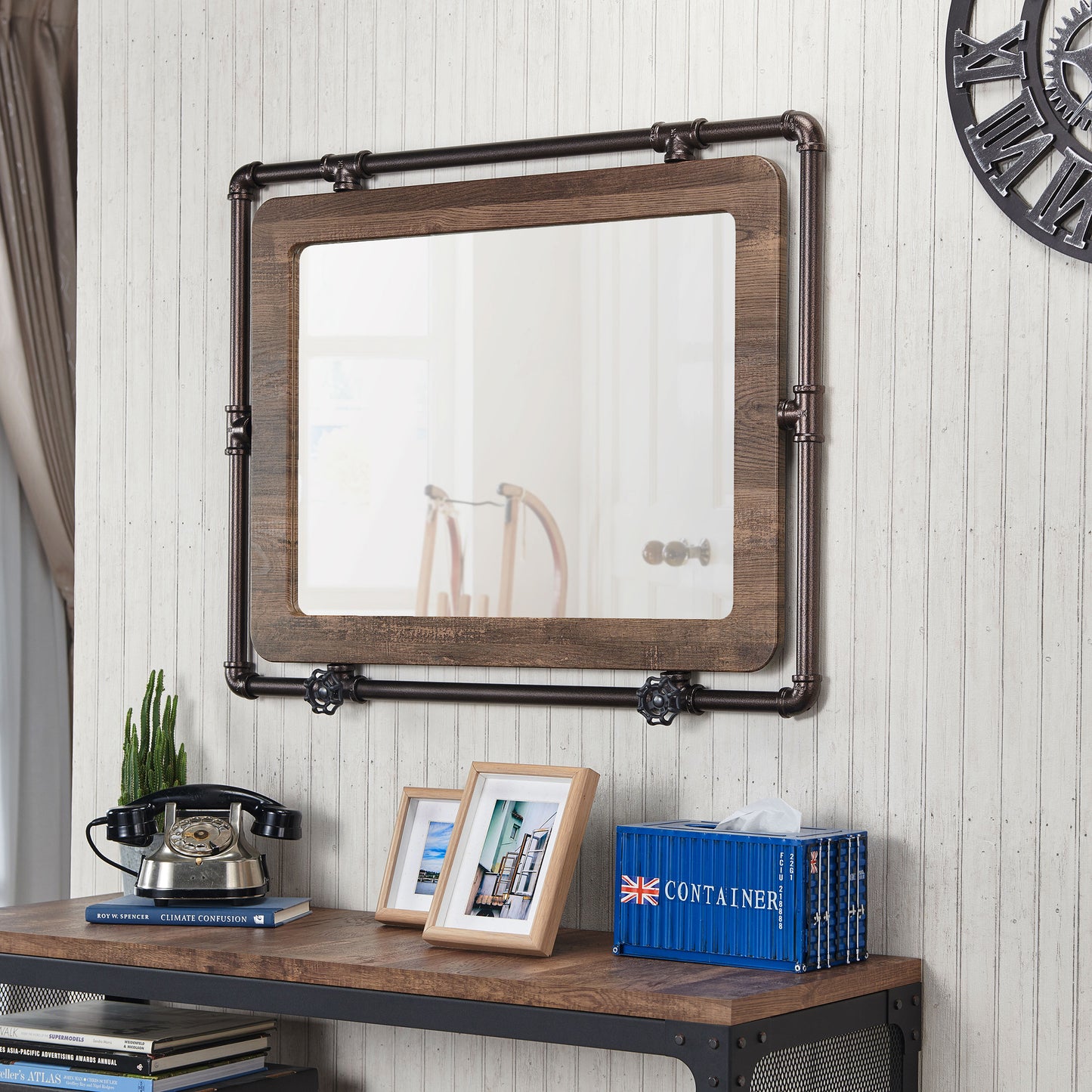 Left angled industrial reclaimed oak and water pipe wall mirror over a table with accessories