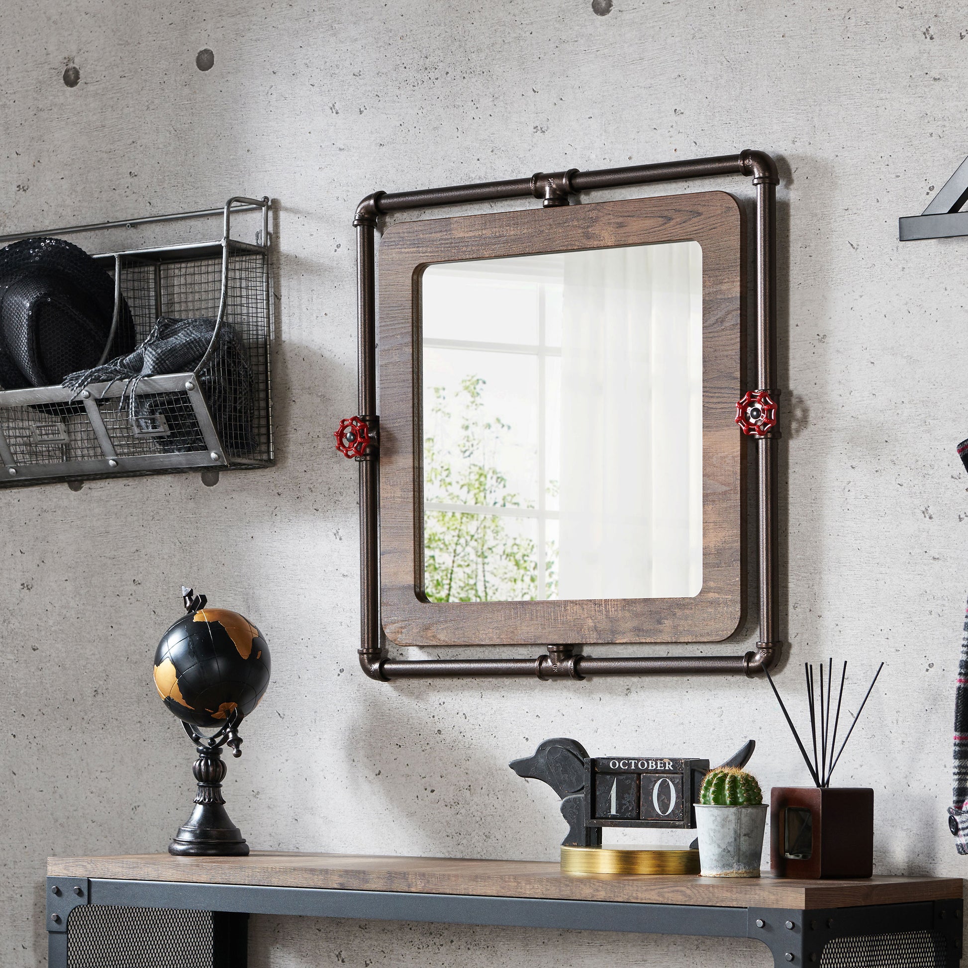 Left angled industrial reclaimed oak and water pipe wall mirror over a table with accessories