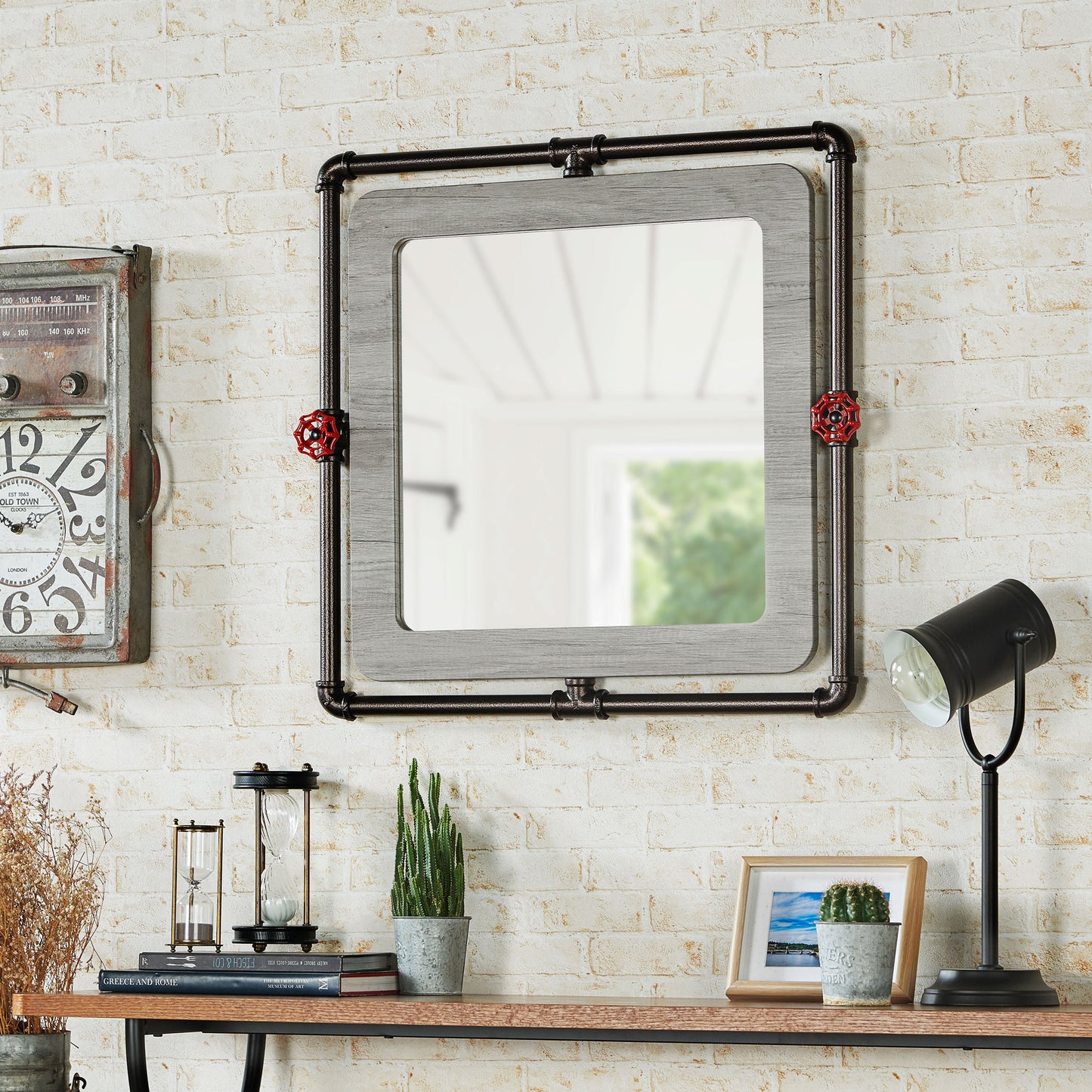 Left angled industrial vintage gray oak and water pipe wall mirror over a table with accessories