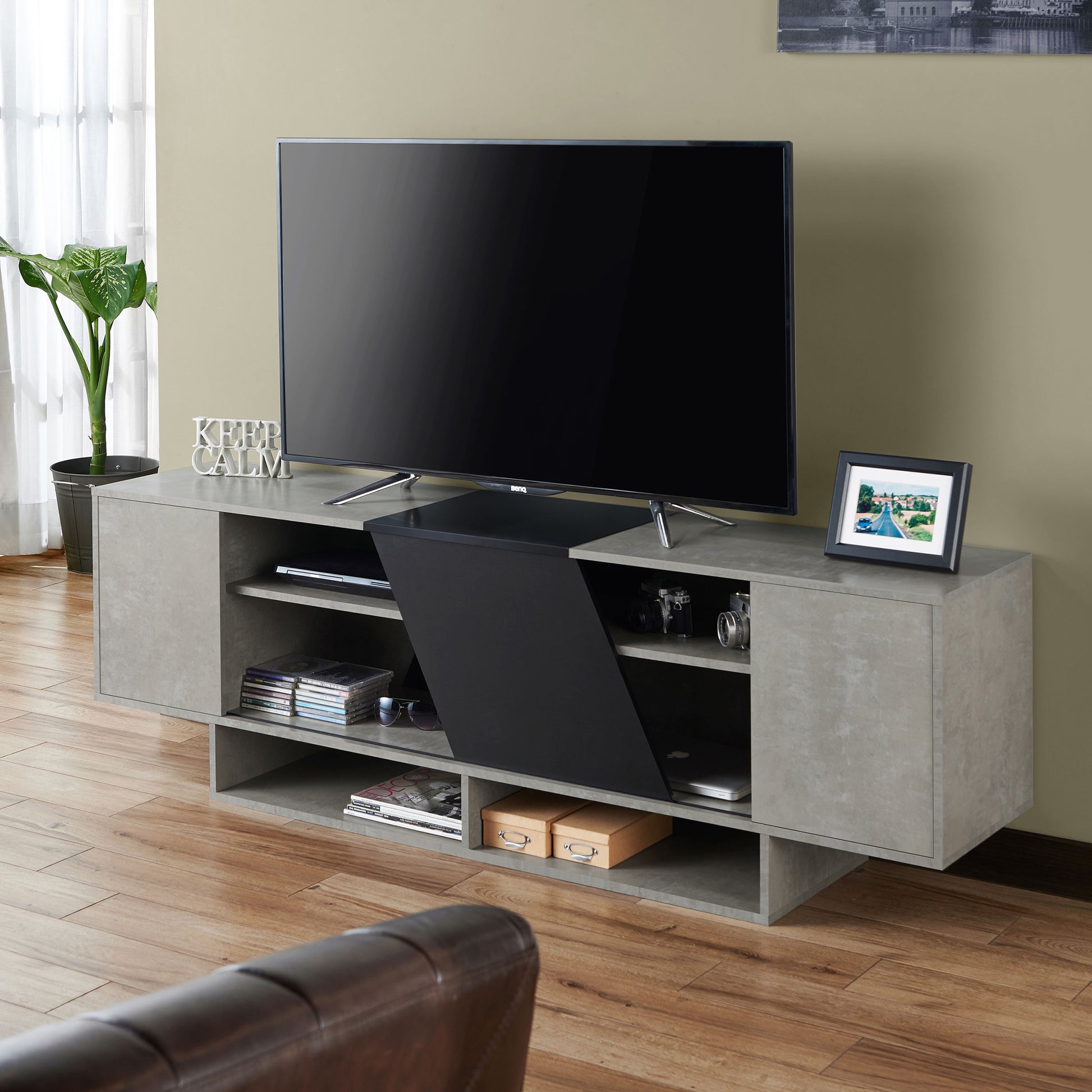 Left angled modern cement gray and black six-shelf TV stand in a living room with accessories