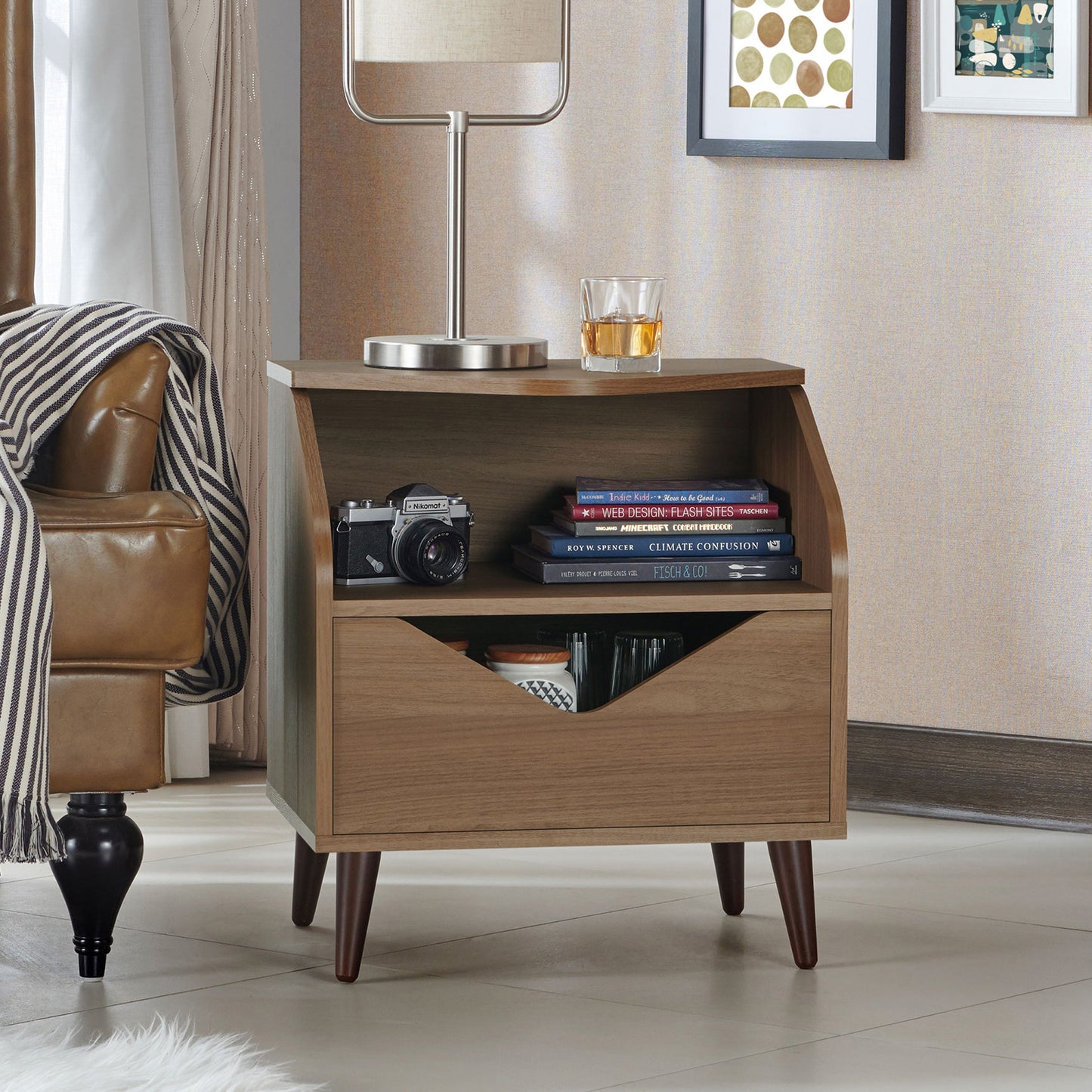 Right angled mid-century modern honey walnut one-drawer end table in a living rea with accessories