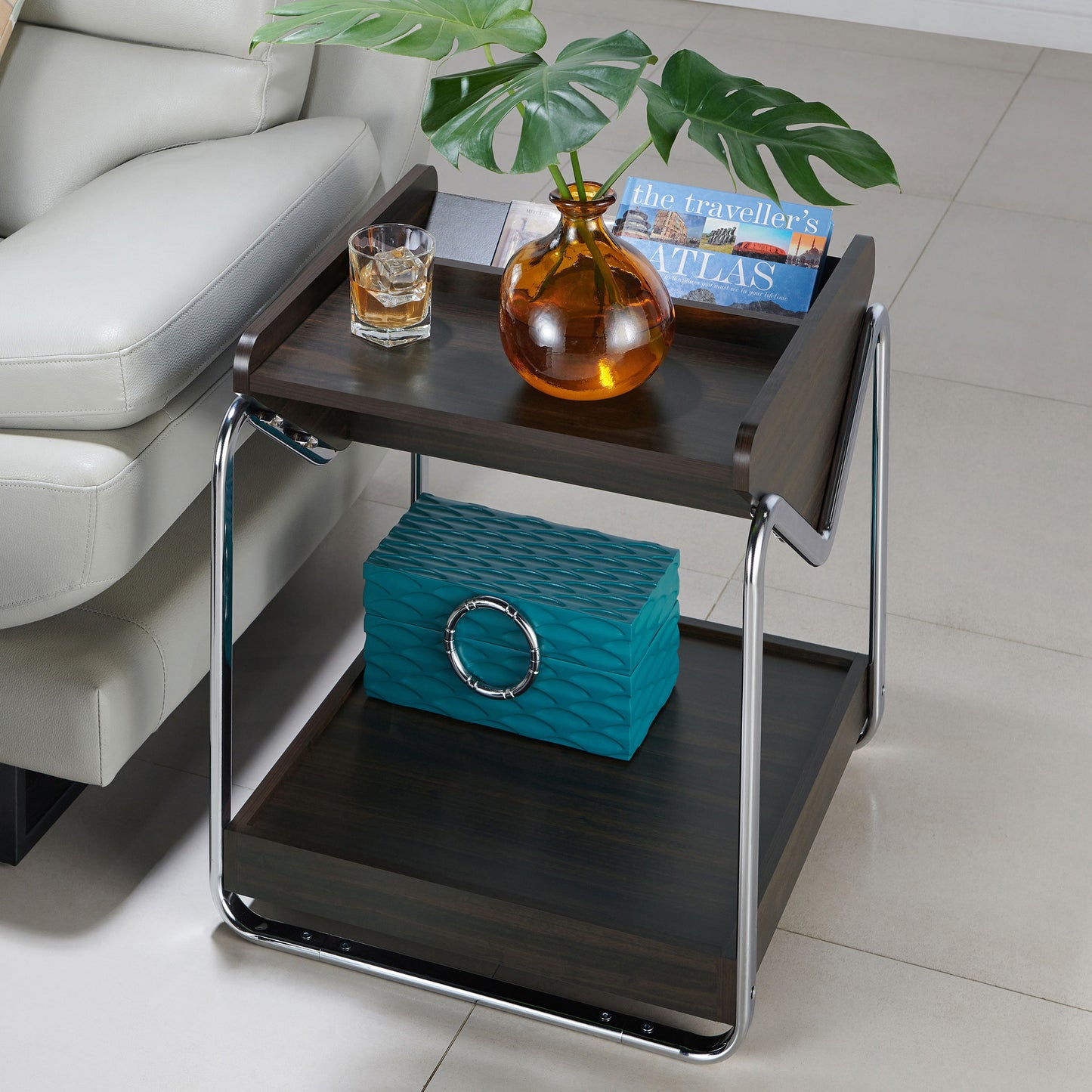 Left angled bird's eye view of a contemporary wenge and chrome three-shelf end table in a living room with accessories
