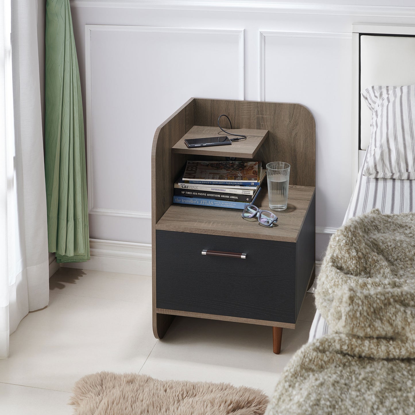 Left angled contemporary chestnut brown one-drawer nightstand with a mini shelf in a bedroom with accessories