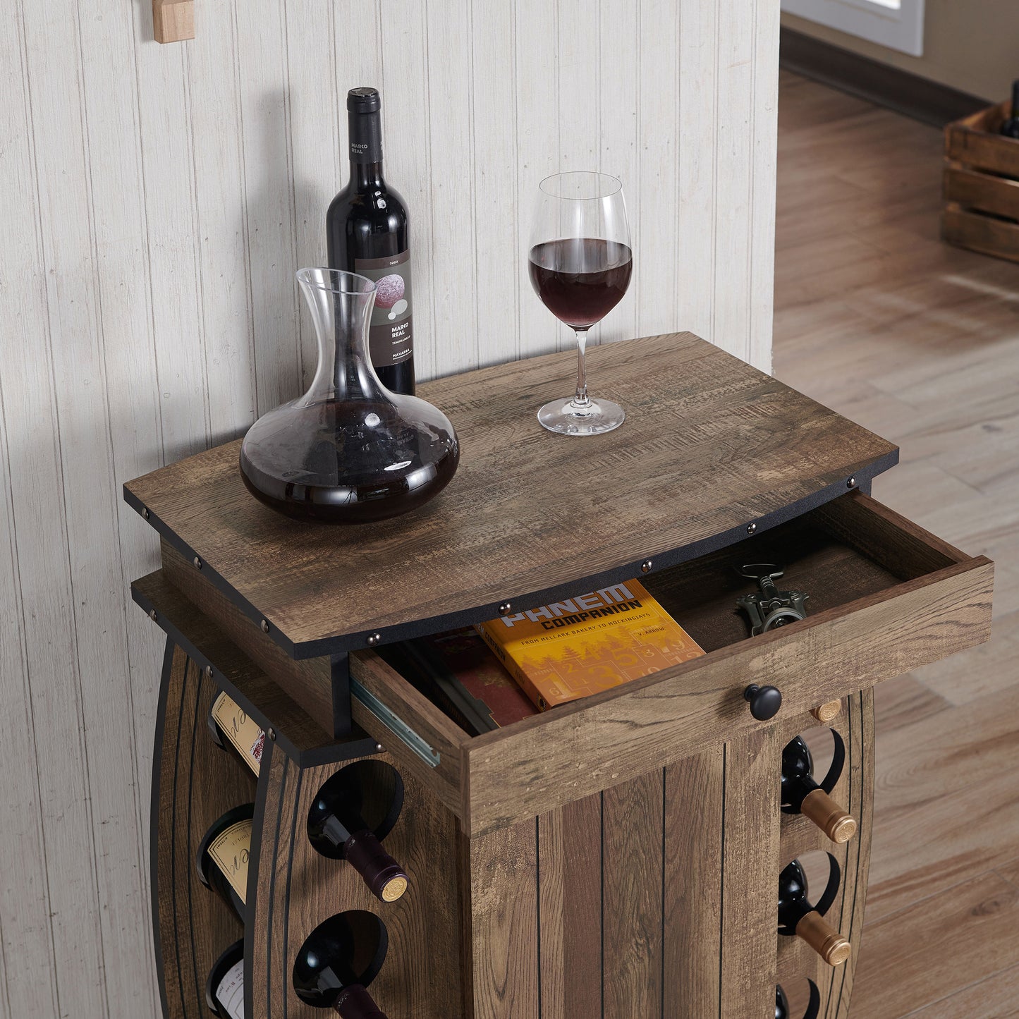 Right angled upper close-up view of a rustic reclaimed oak bar cabinet with an eight-bottle wine rack with drawer open in a living area with bottles and accessories