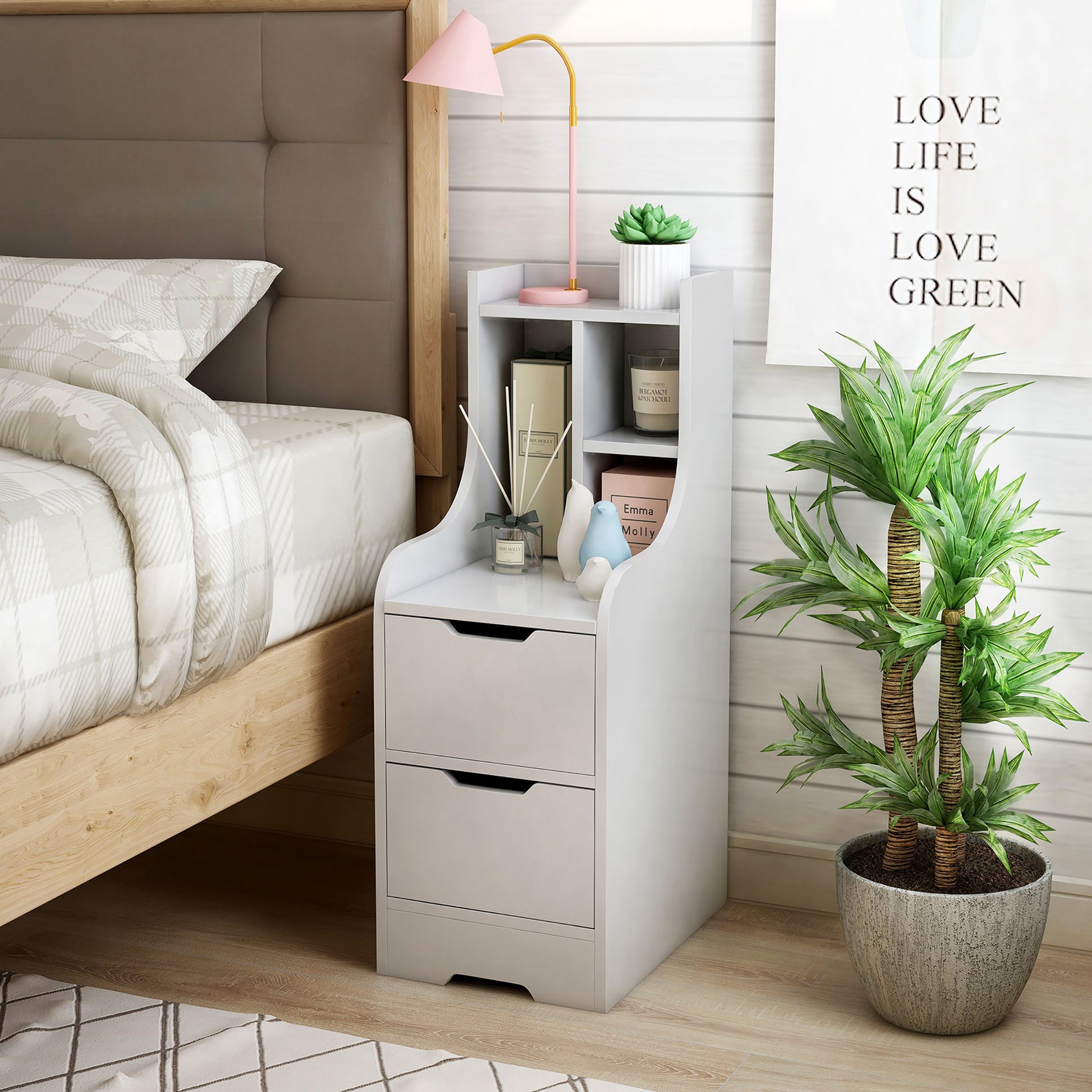 Left angled modern white two-drawer nightstand with shelves in a bedroom with accessories