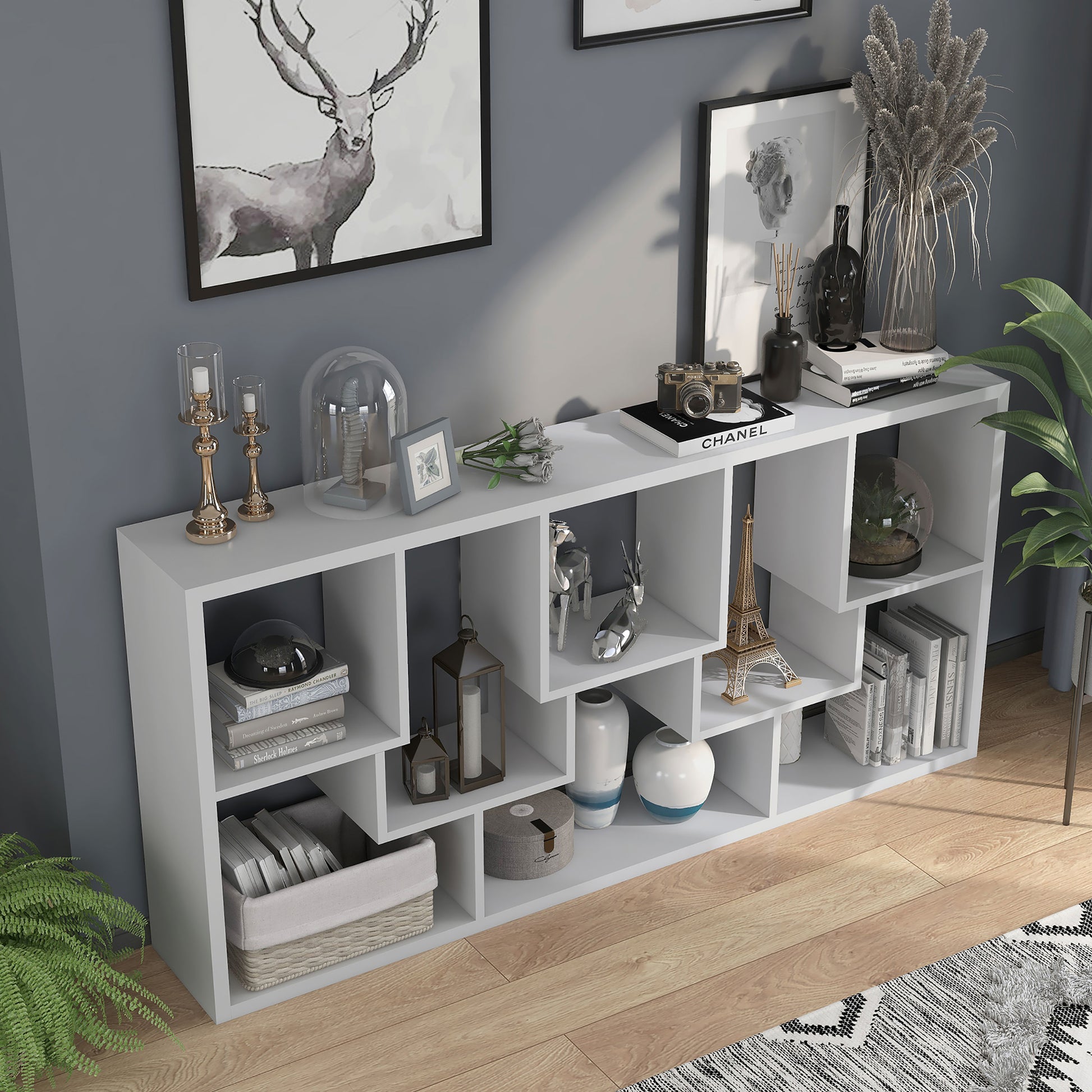 Right angled bird's eye view of a horizontal modern white geometric open display bookcase in a living room with accessories