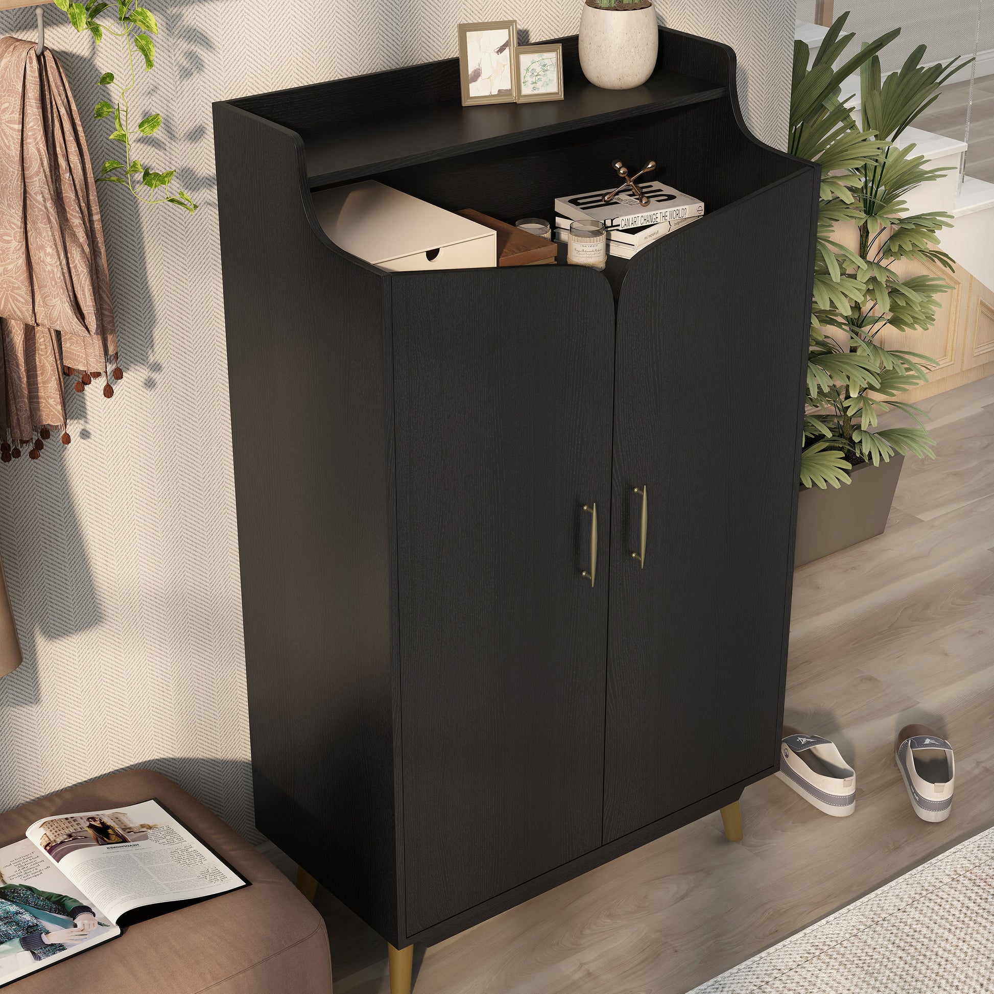 Right angled upper view of a transitional black and gold two-door 14-pair shoe cabinet in an entryway with accessories