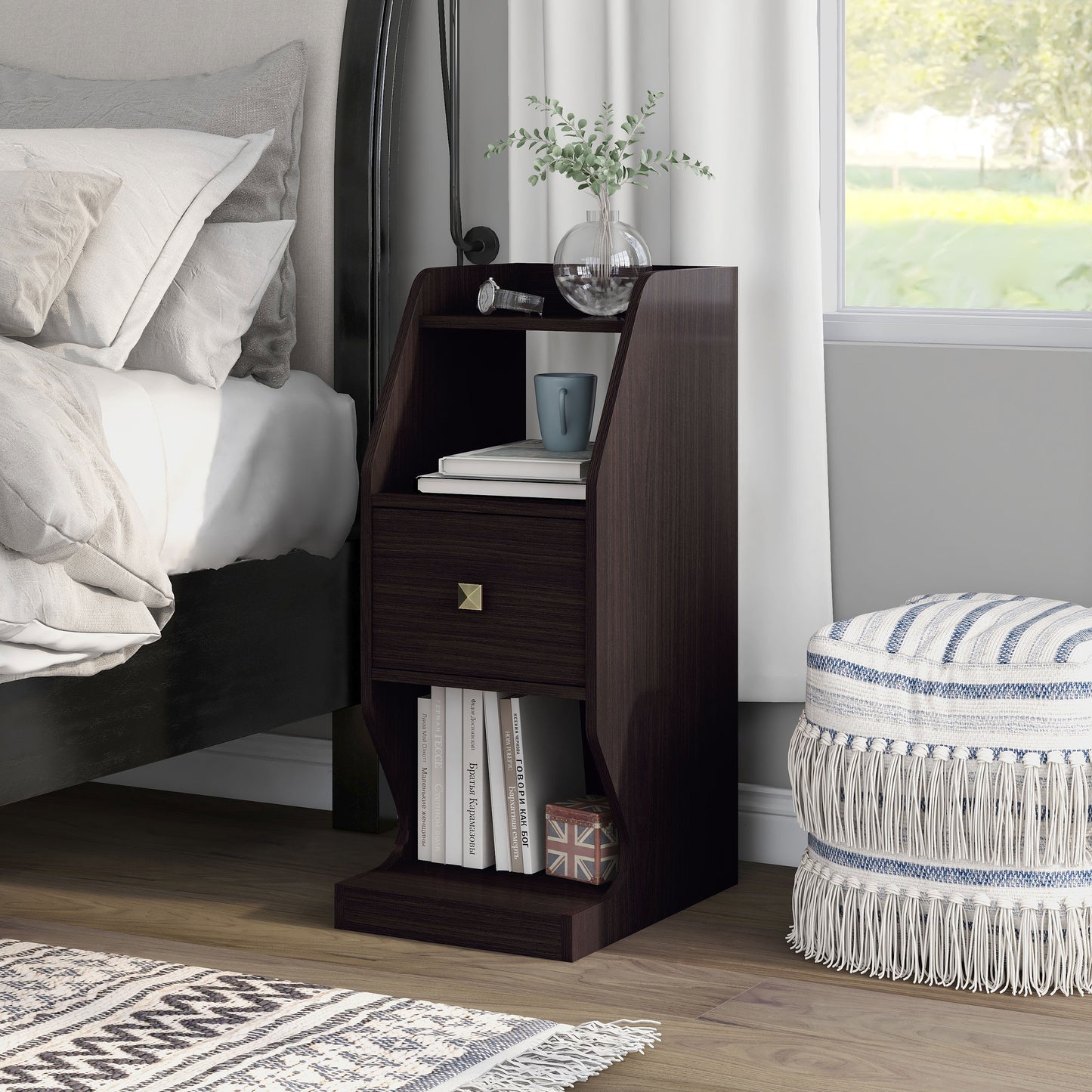 Left angled transitional espresso tiered one-drawer nightstand in a bedroom with accessories