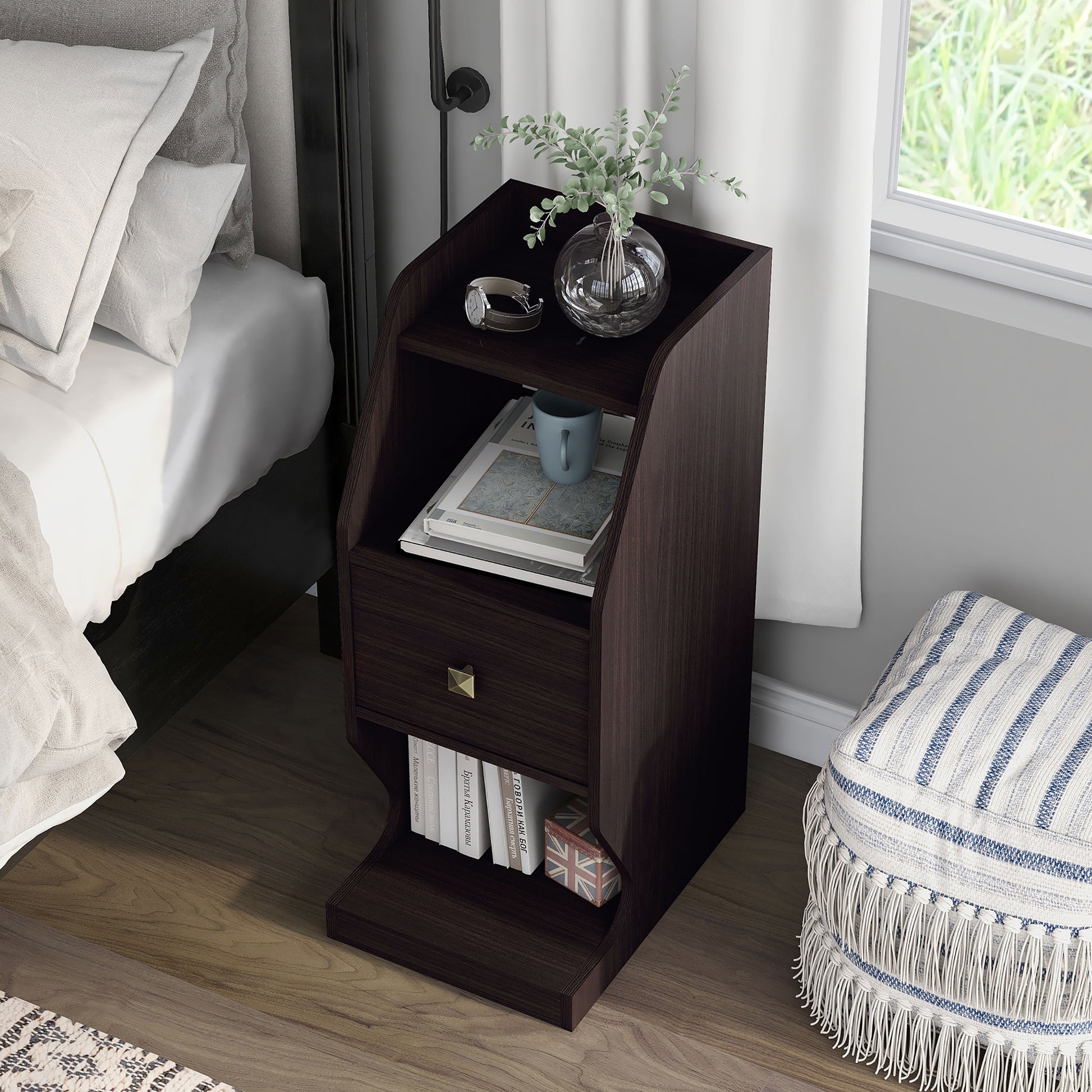 Left angled upper view of a transitional espresso tiered one-drawer nightstand in a bedroom with accessories