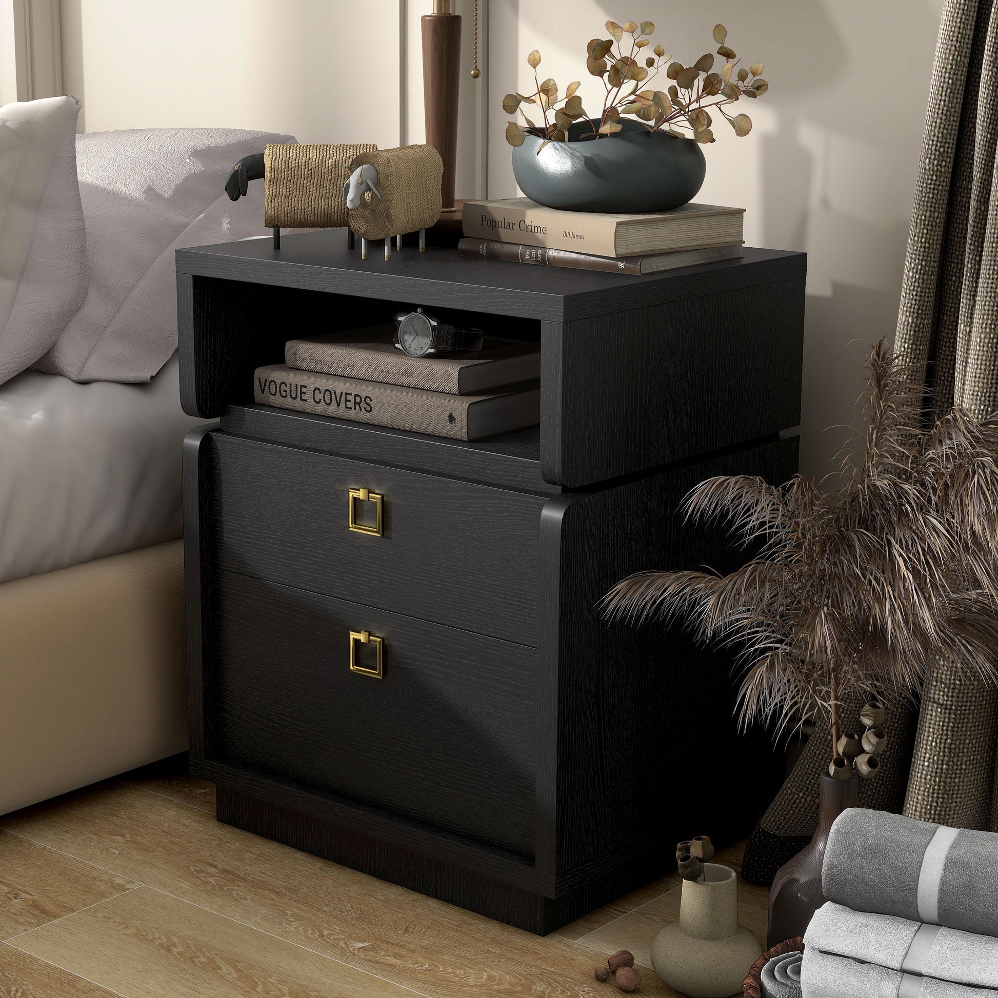 Left angled modern black two-drawer nightstand/end table in a bedroom with accessories