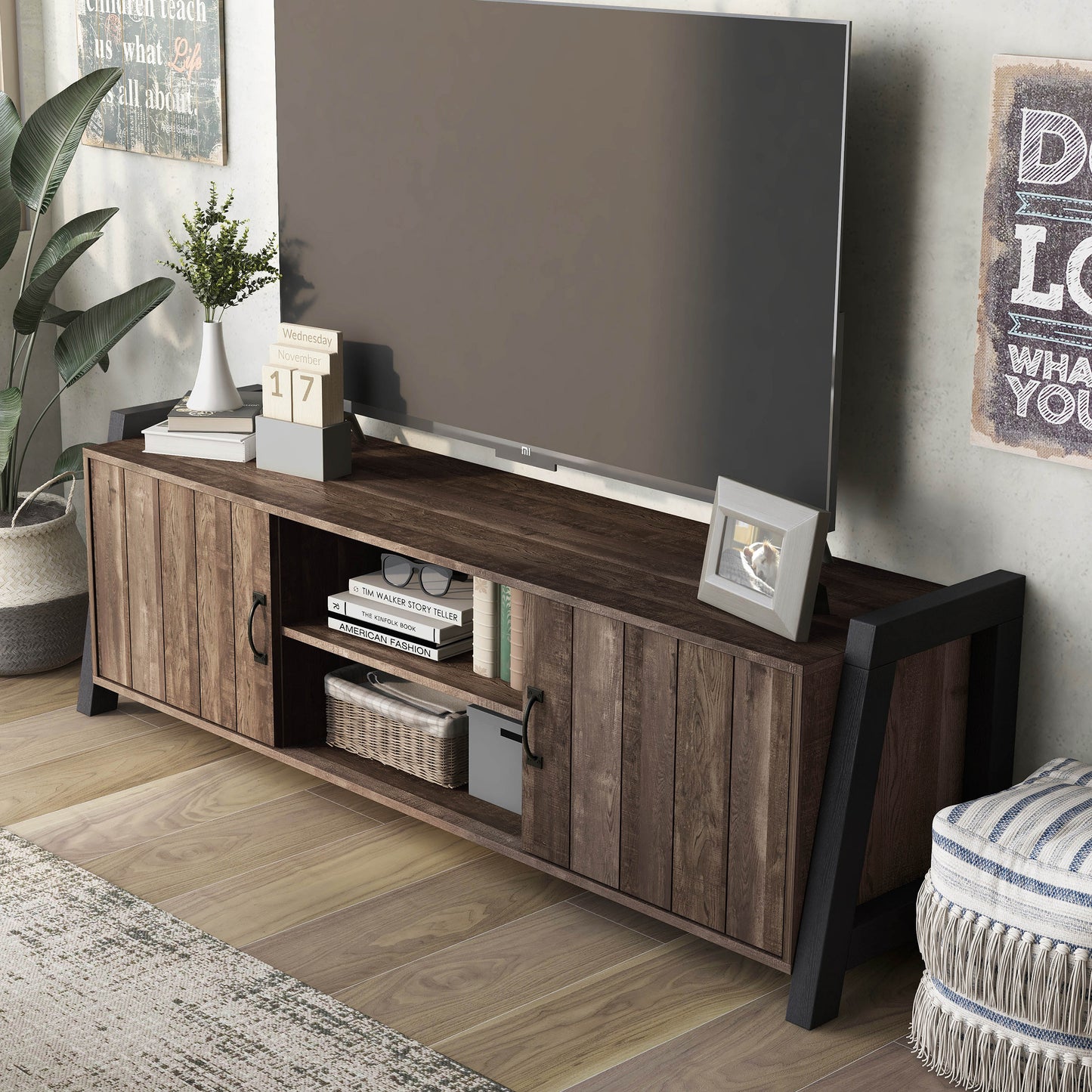 Left angled upper view of a farmhouse reclaimed oak and black six-shelf TV stand in a living room with accessories