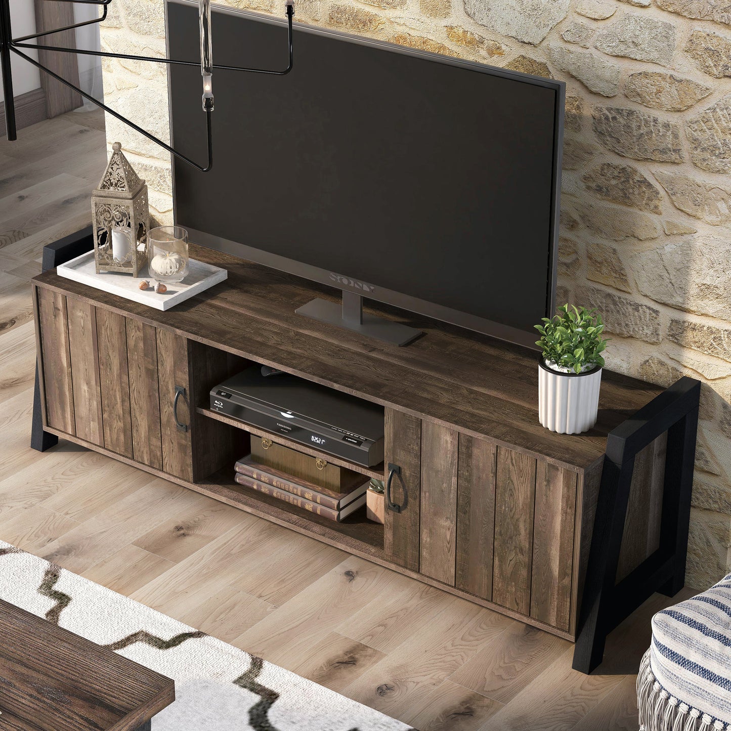 Left angled bird's eye view of a farmhouse reclaimed oak and black six-shelf TV stand in a living room with accessories