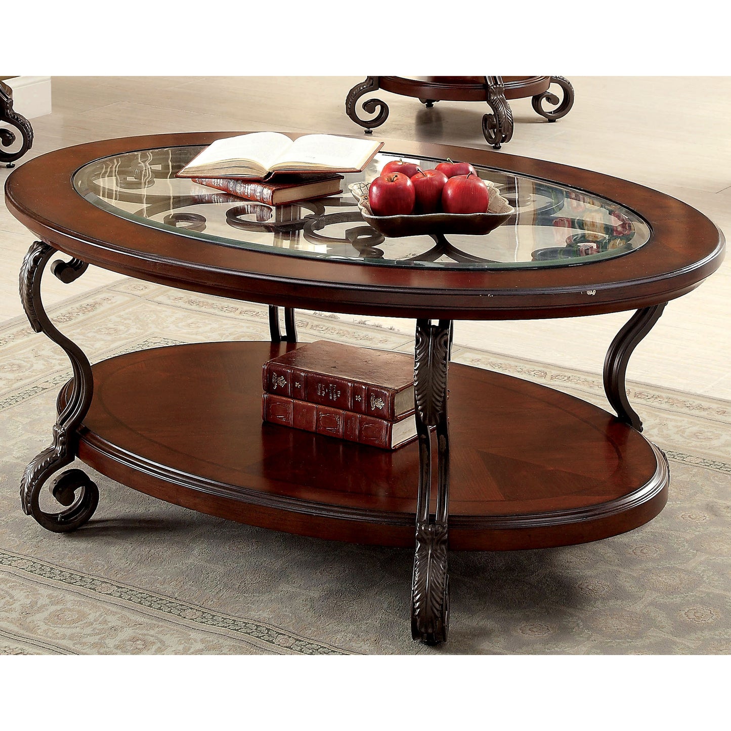Angled traditional brown cherry and glass oval coffee table with a lower shelf on a rug with accessories