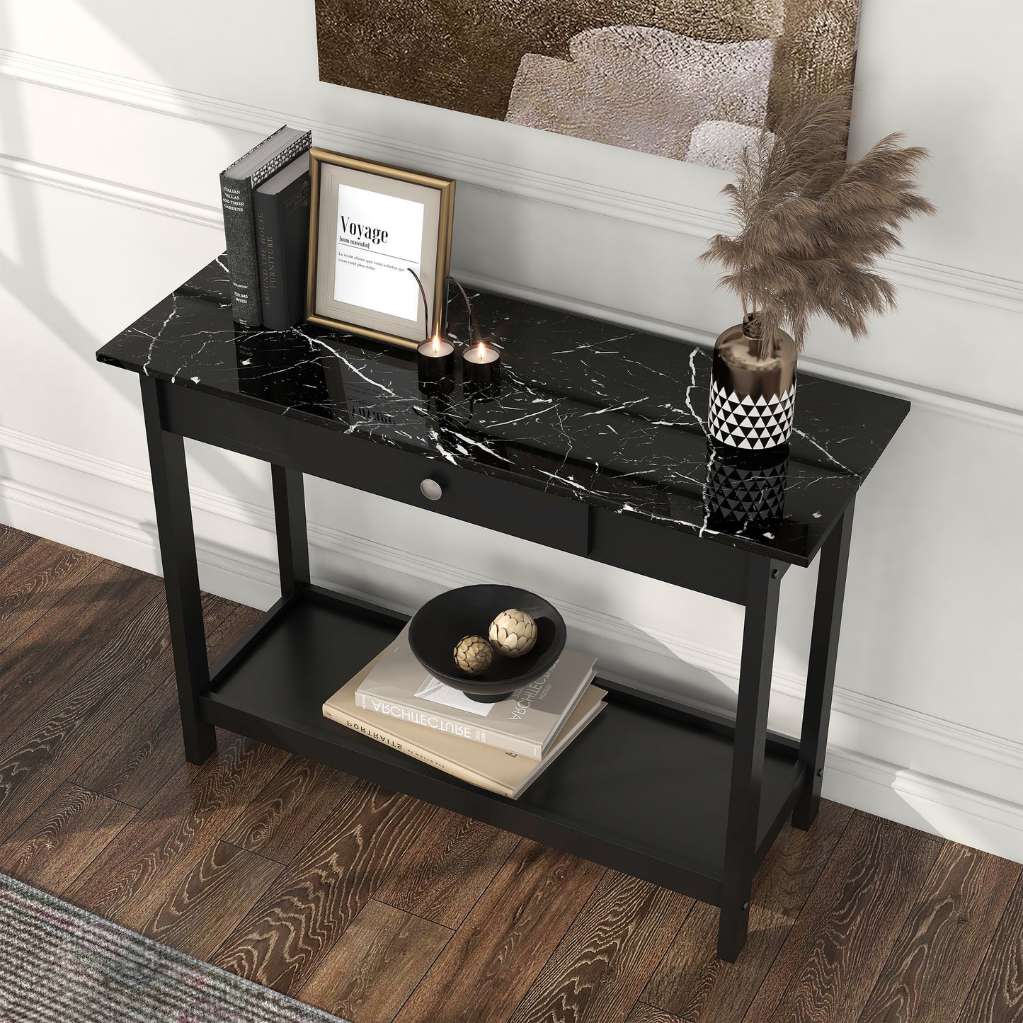 Left angled bird's eye view of a modern black and faux marble one-drawer console table with a lower shelf in a living area with accessories