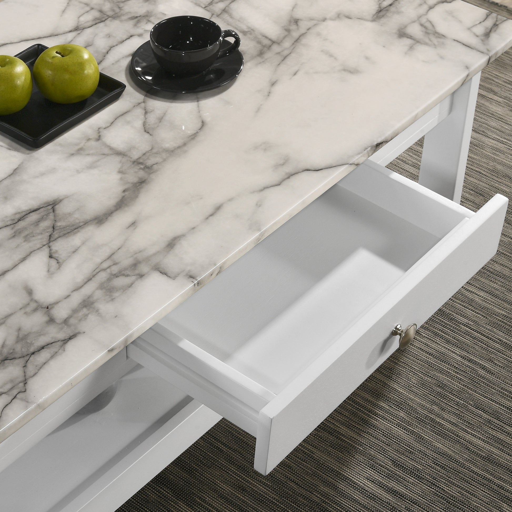 Right angled coffee table only close-up drawer detail view of a three-piece modern white and faux marble coffee table set with lower shelves in a living area with accessories