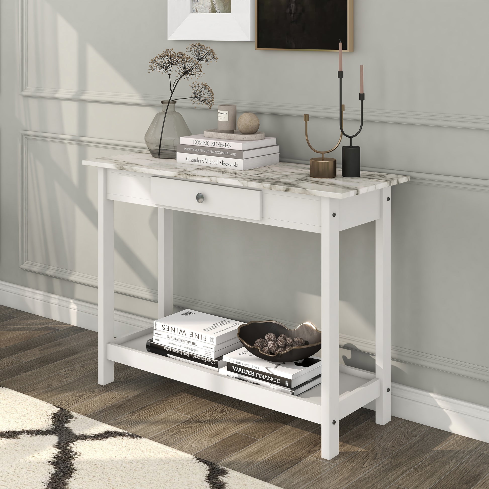 Left angled modern white and faux marble console table with a lower shelf in a living area with accessories
