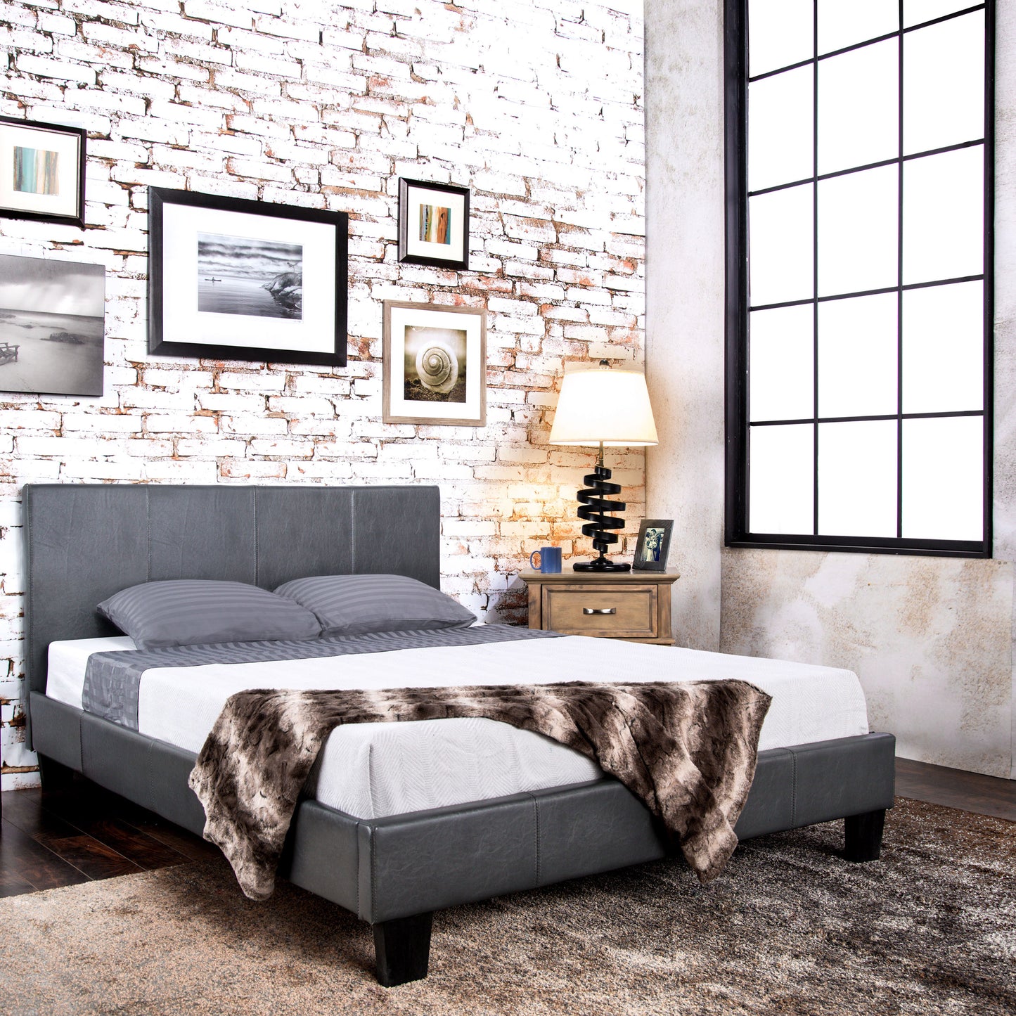 Right angled contemporary gray faux leather full platform bed in a bedroom with accessories