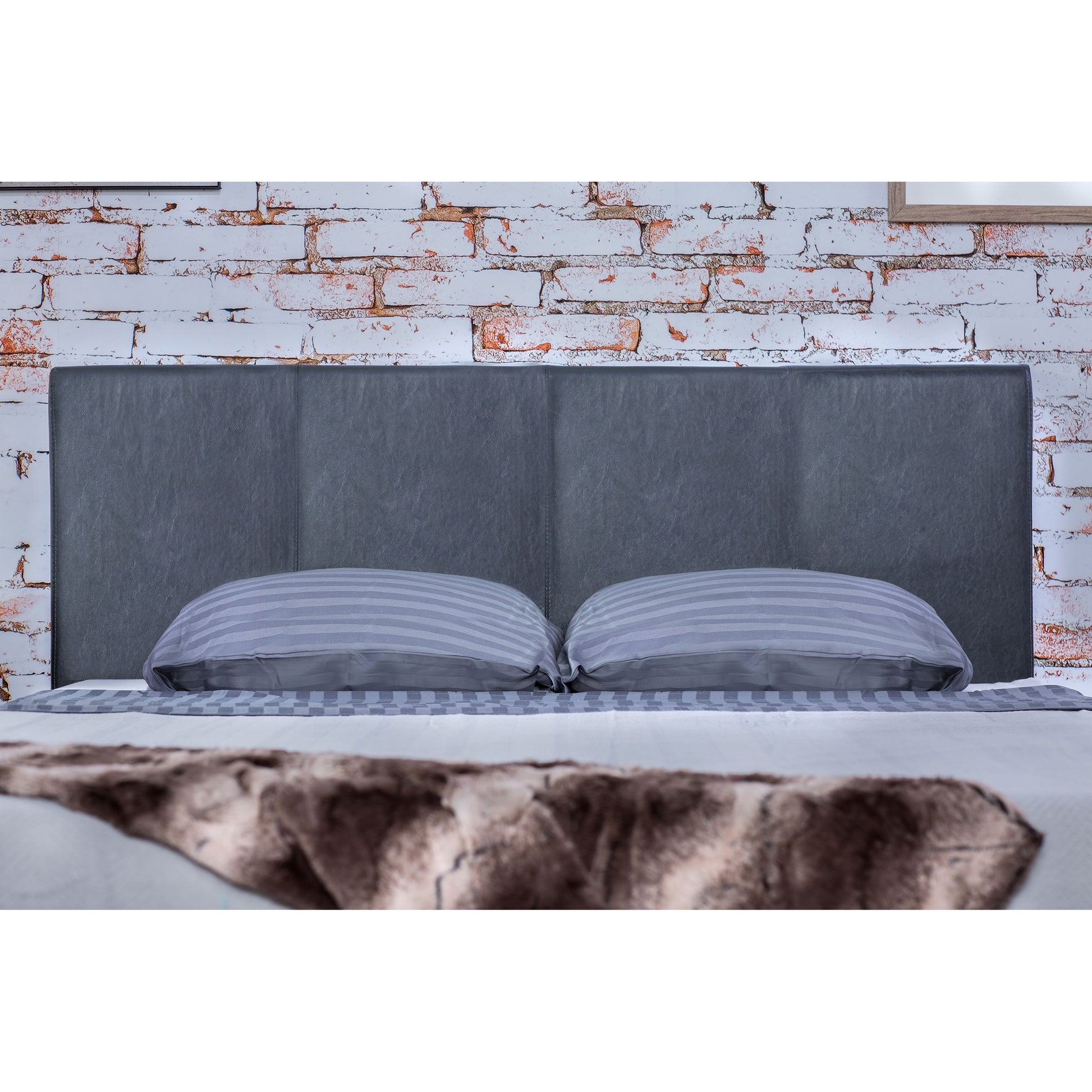 Front-facing headboard focus on a contemporary gray faux leather full platform bed in a bedroom with accessories