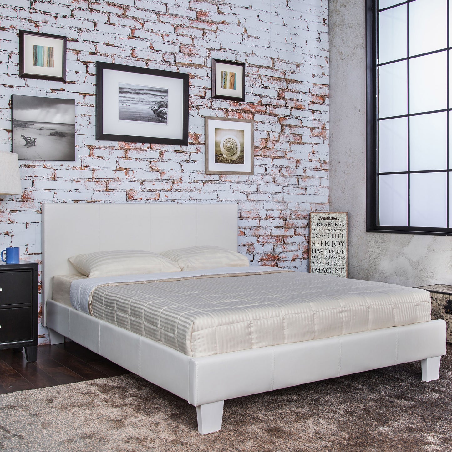 Right angled contemporary white faux leather full platform bed in a bedroom with accessories
