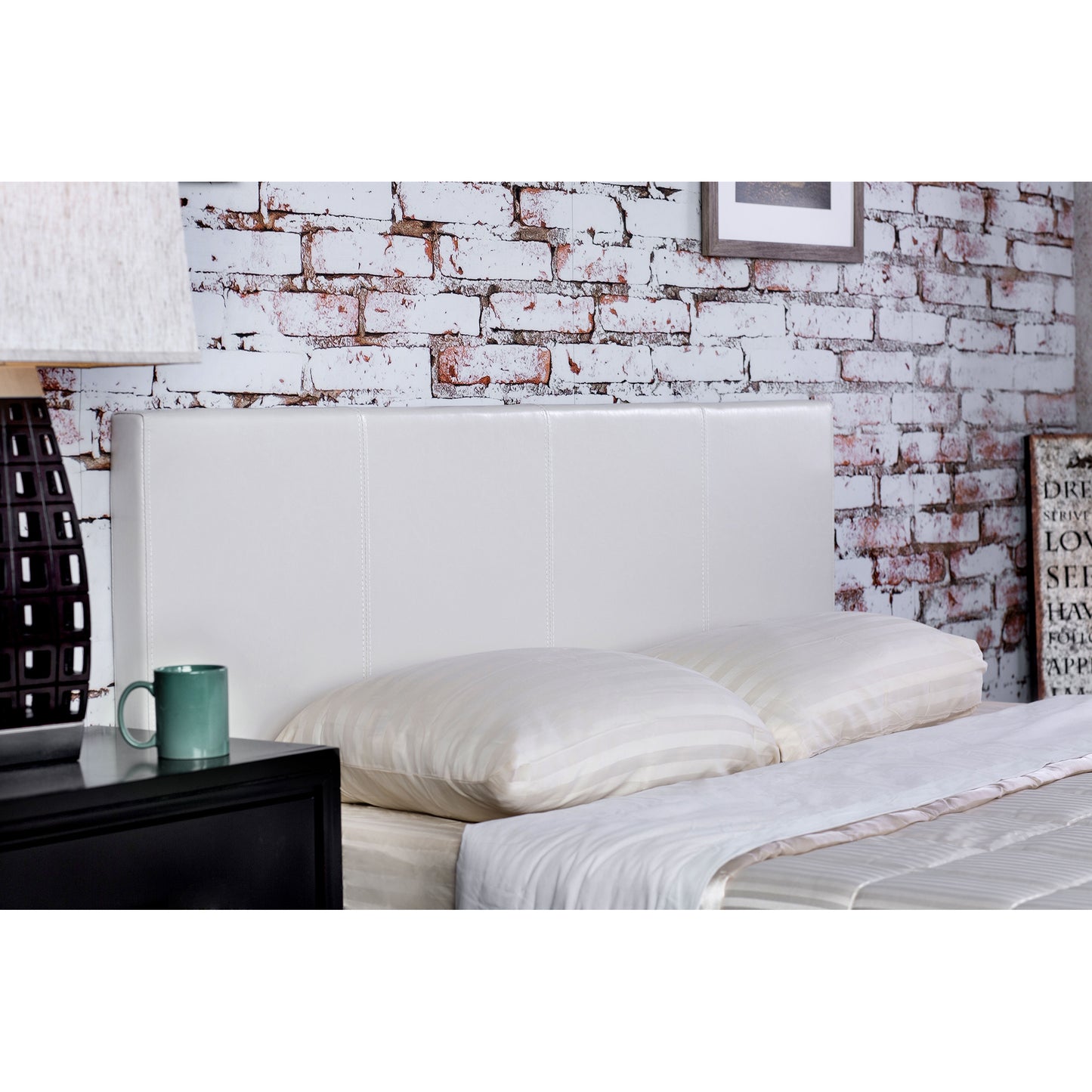 Right angled headboard detail on a contemporary white faux leather full platform bed in a bedroom with accessories