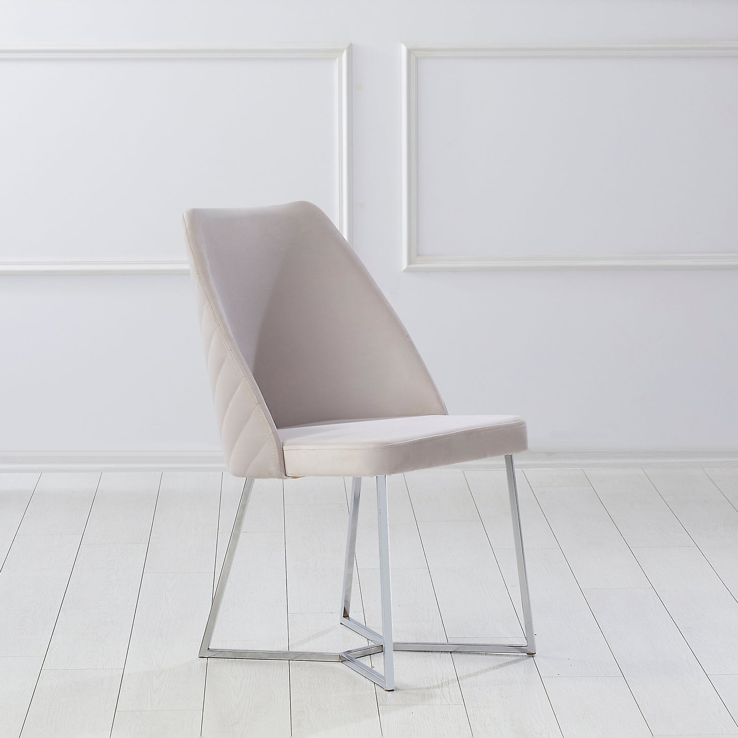 Right angled single chair only from a set of two contemporary white microfiber and silver dining chairs in an empty room with white floors
