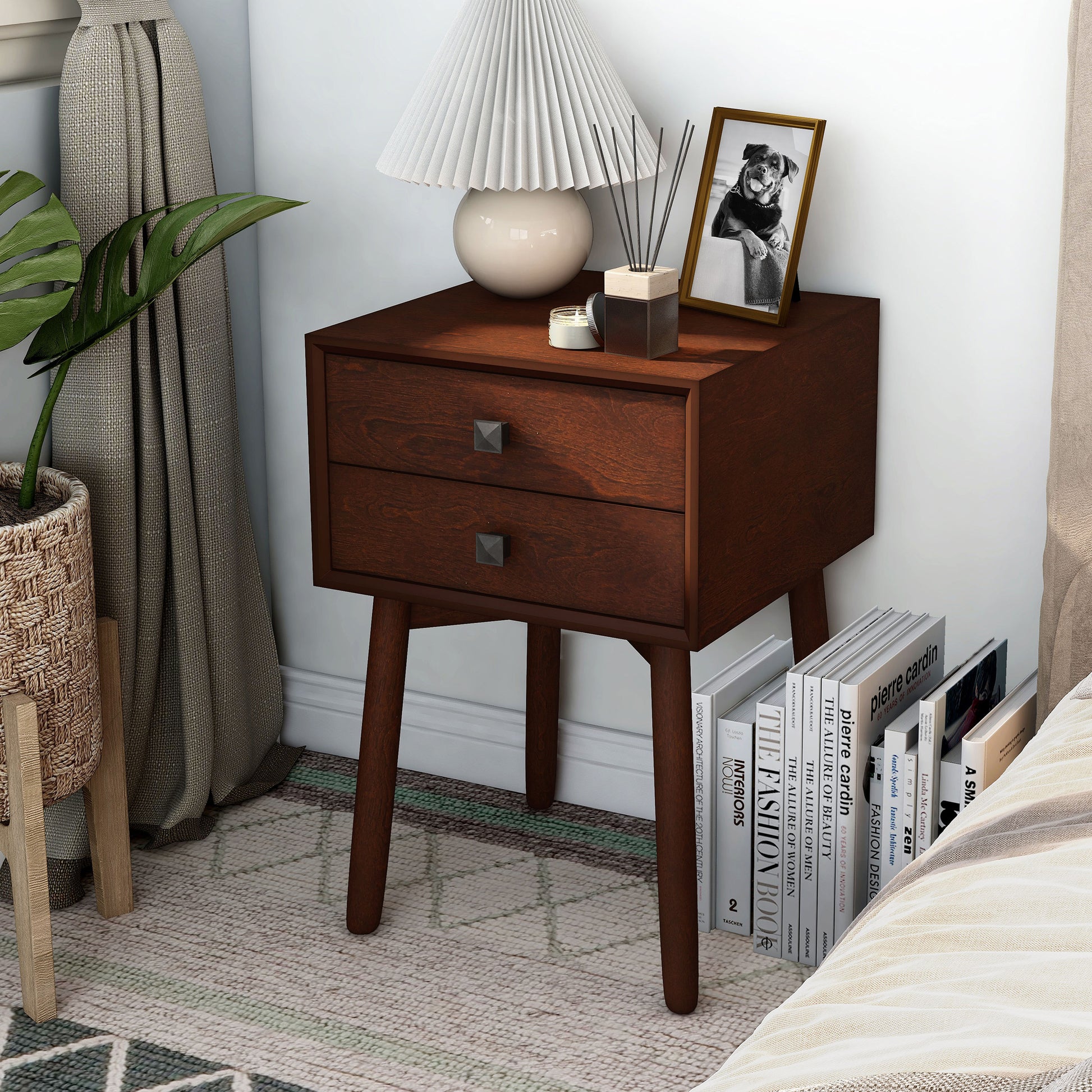Left angled modern espresso two-drawer compact nightstand with splayed legs in a bedroom with accessories