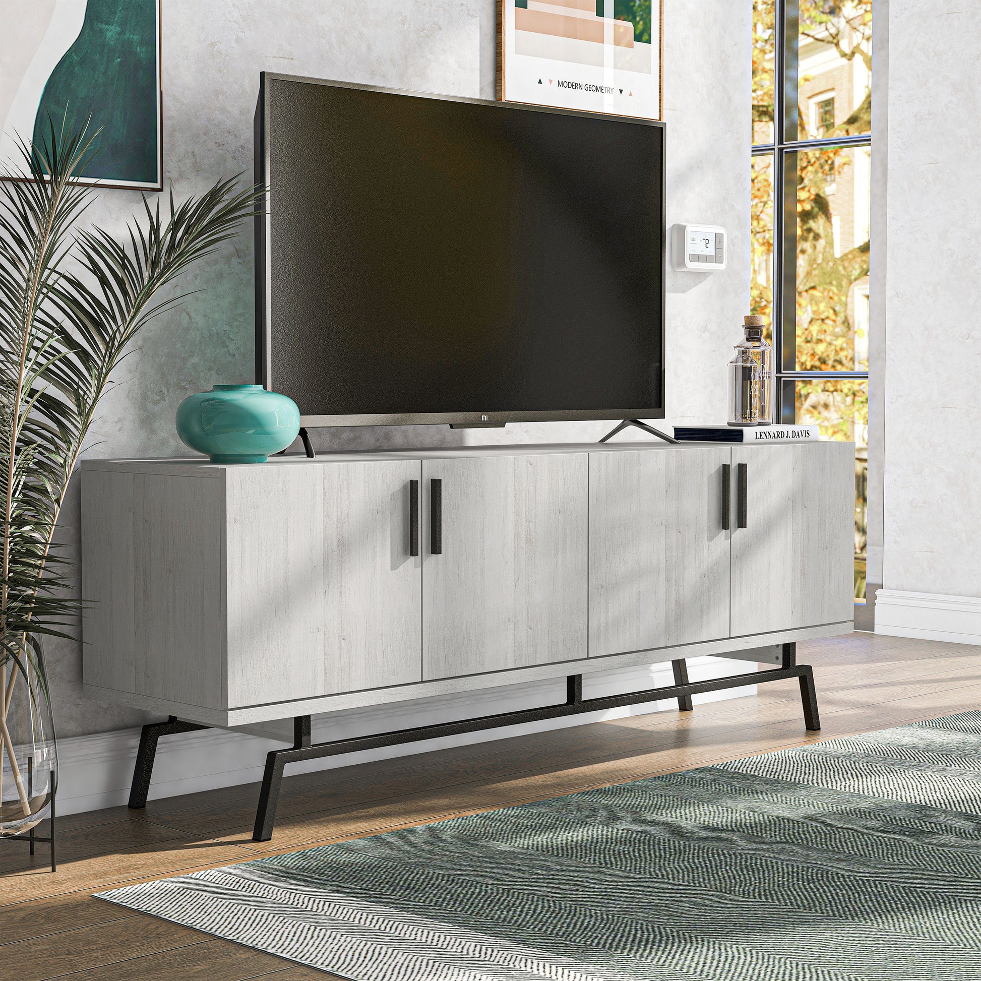 Right angled modern white oak and black four-door TV stand in a living room with accessories