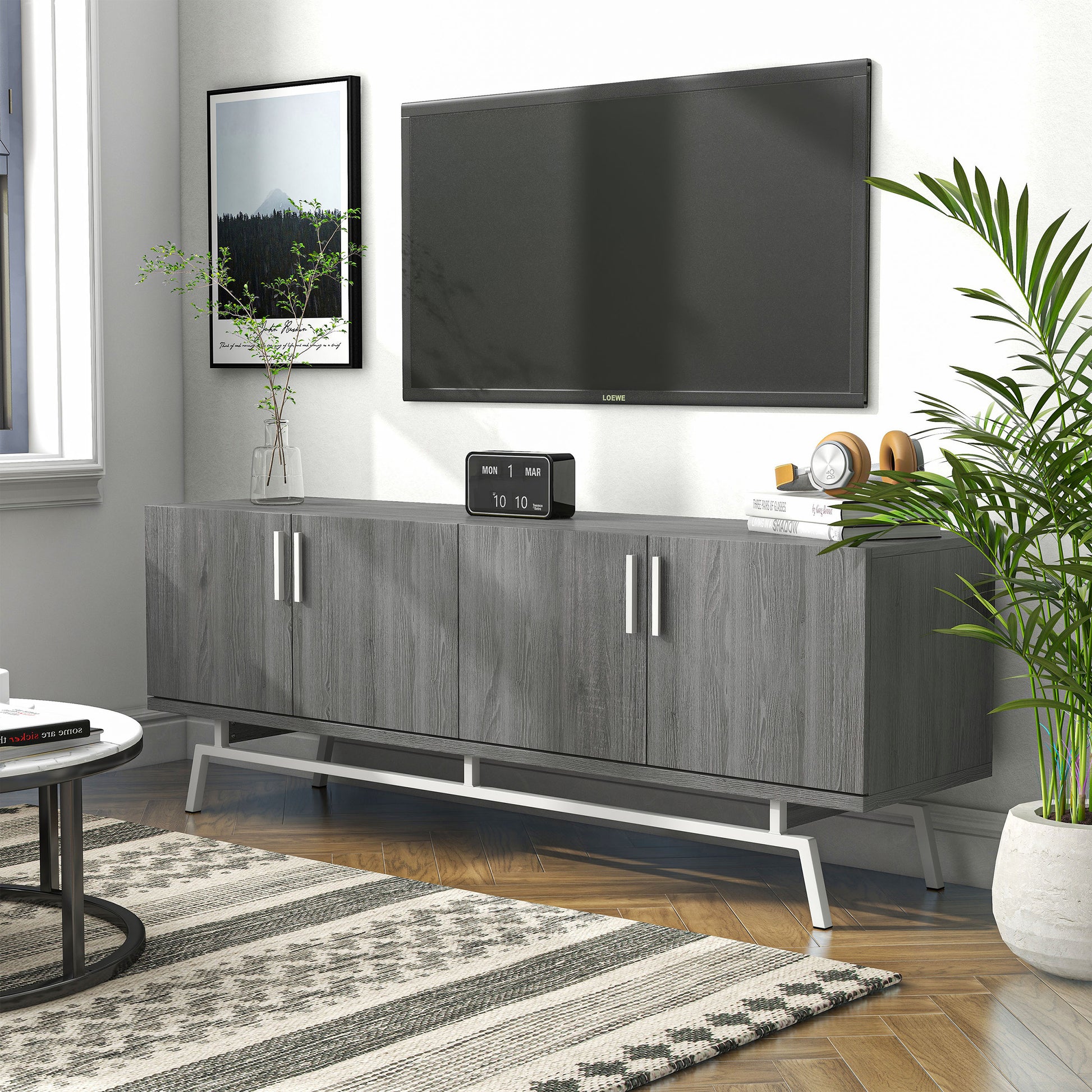 Left angled modern distressed gray and silver four-door TV stand in a living room with accessories