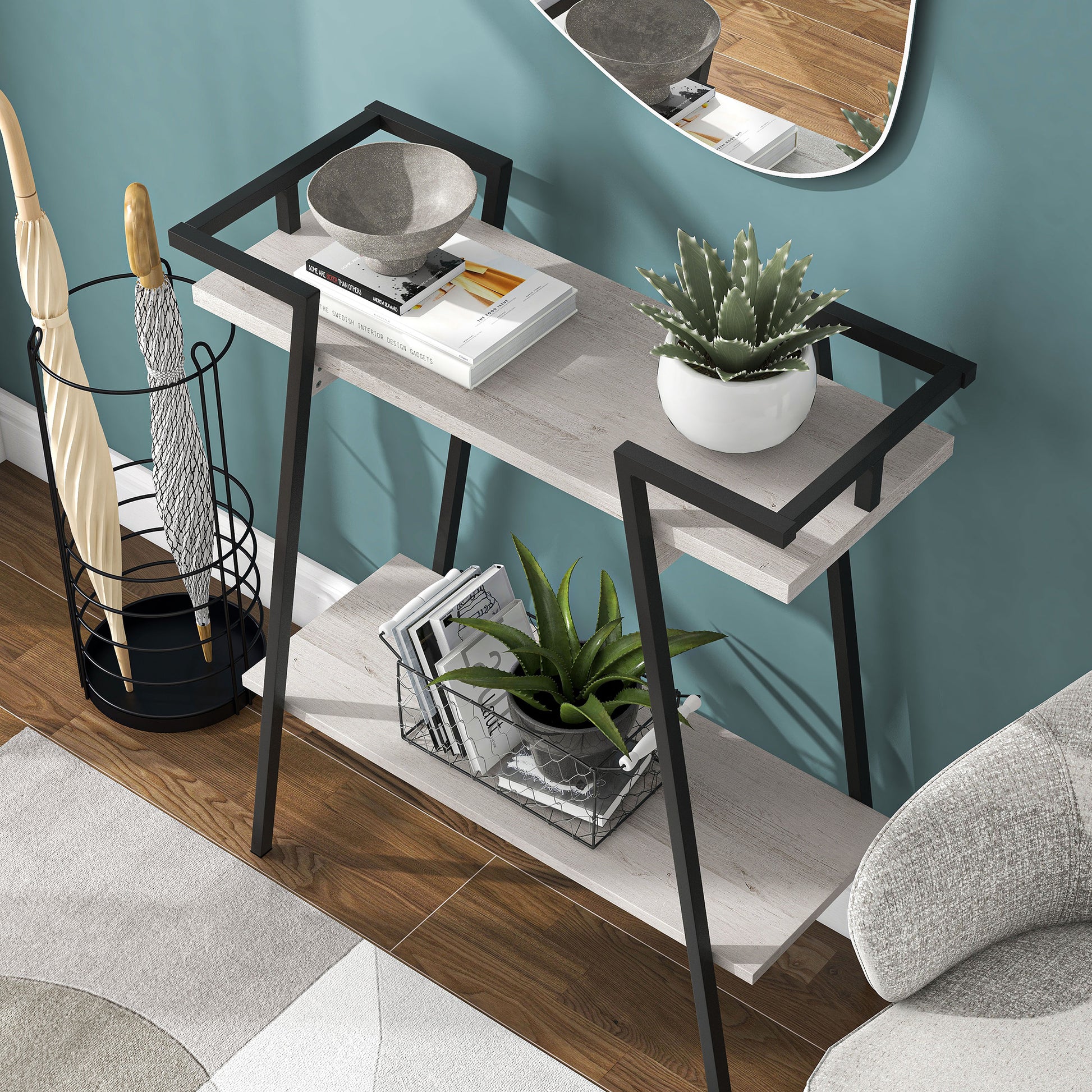 Left angled bird's eye view of a urban industrial white oak and black two-shelf geometric console table in an entry with accessories