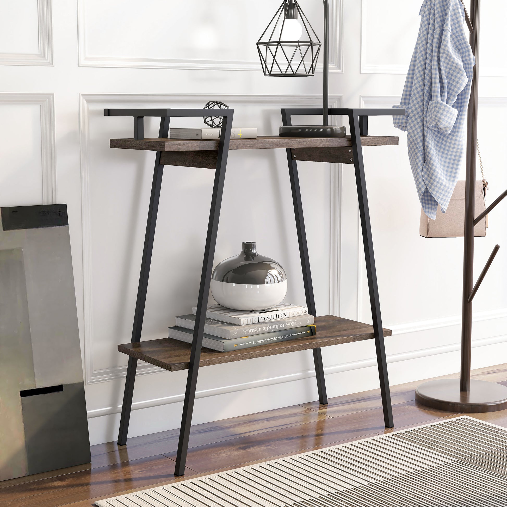 Right angled urban industrial walnut oak and black two-shelf geometric console table in an entry with accessories