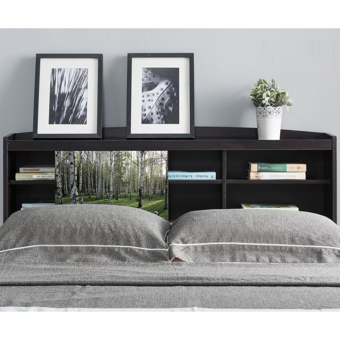 Front-facing contemporary cappuccino six-shelf bookcase headboard with sliding center panel to one side in a bedroom with accessories