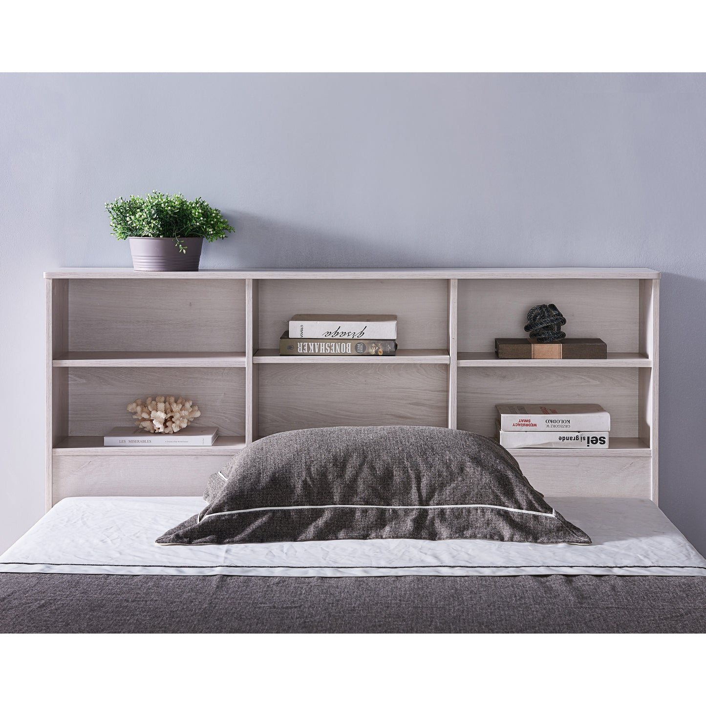 Front-facing optional headboard detail view of a contemporary three-drawer storage bed in a bedroom with accessories