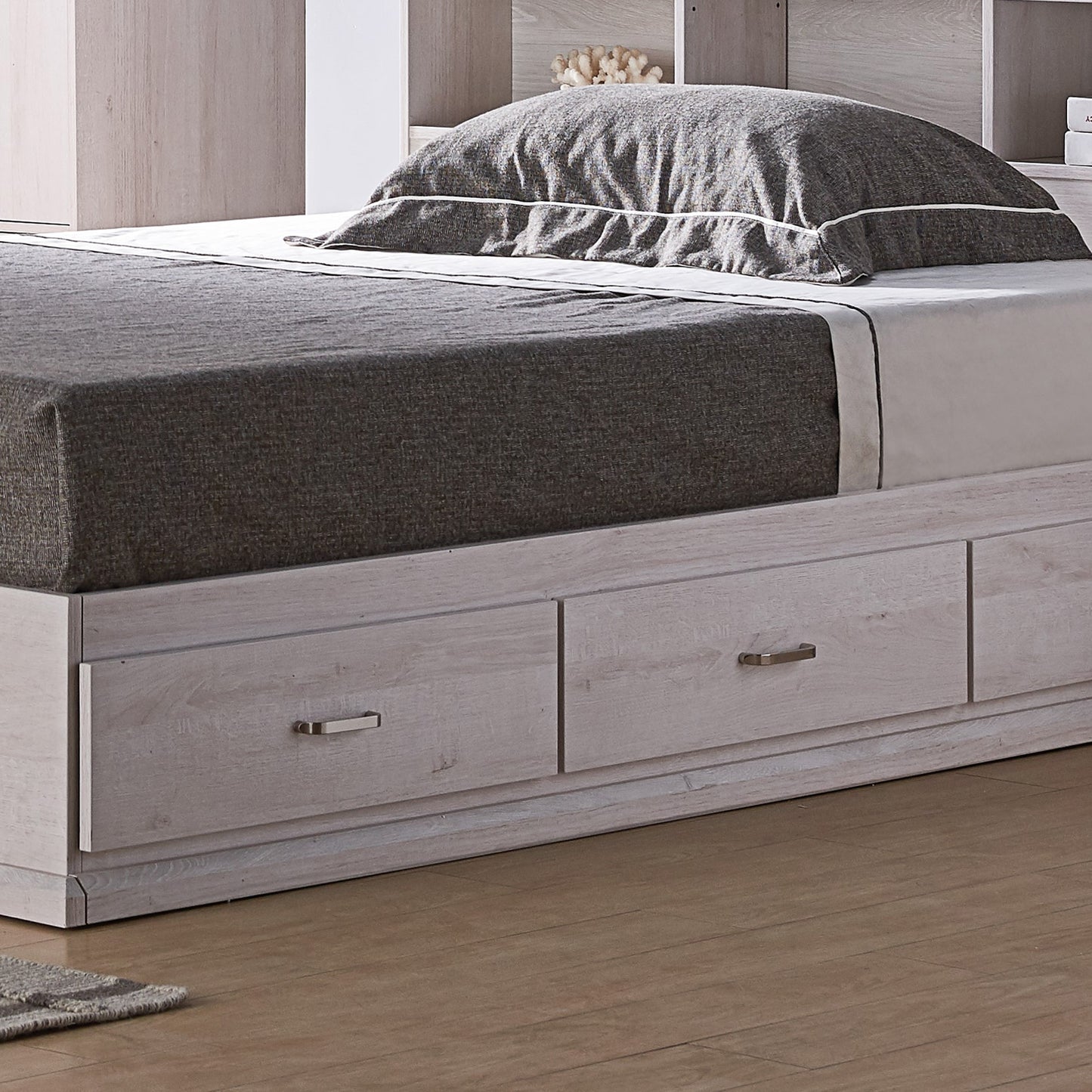 Left angled drawer close-up view of a contemporary three-drawer storage bed in a bedroom with accessories