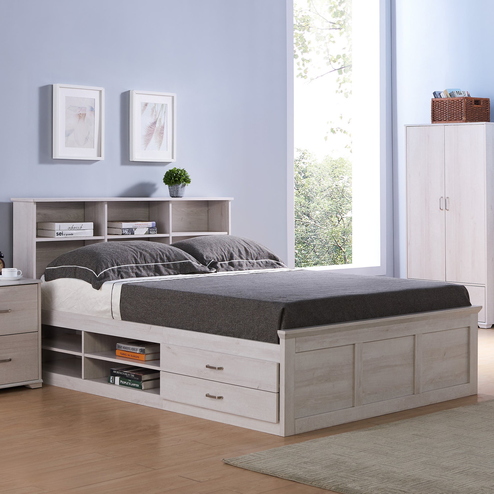 Right angled transitional white oak two-drawer four-shelf storage bed shown with optional bookcase headboard in a bedroom with accessories