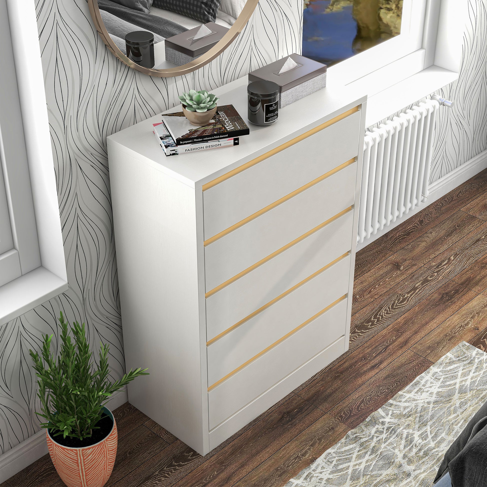 Right angled bird's eye view of a modern white and gold five-drawer tall dresser in a bedroom with accessories