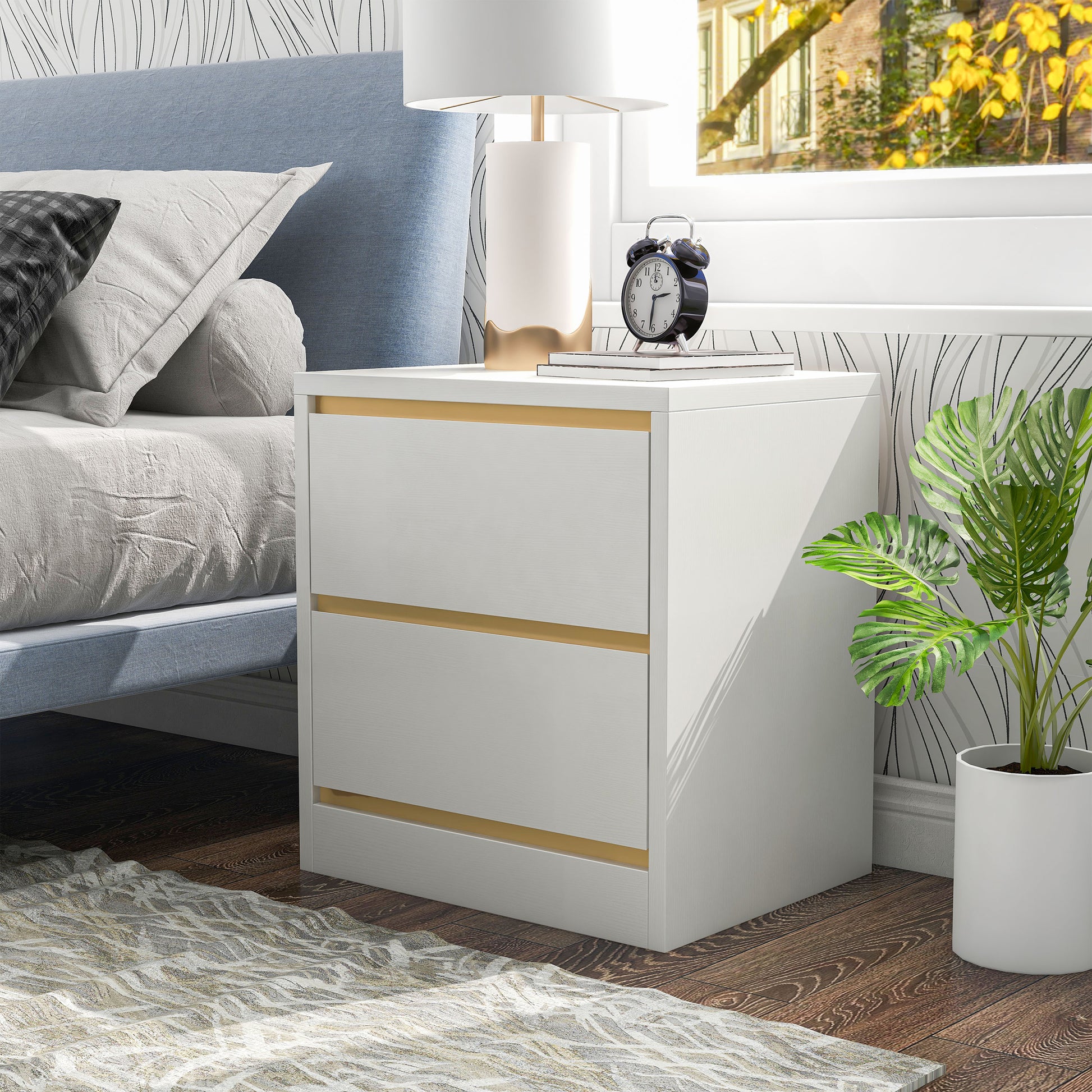 Left angled modern white and gold two-drawer nightstand in a bedroom with accessories