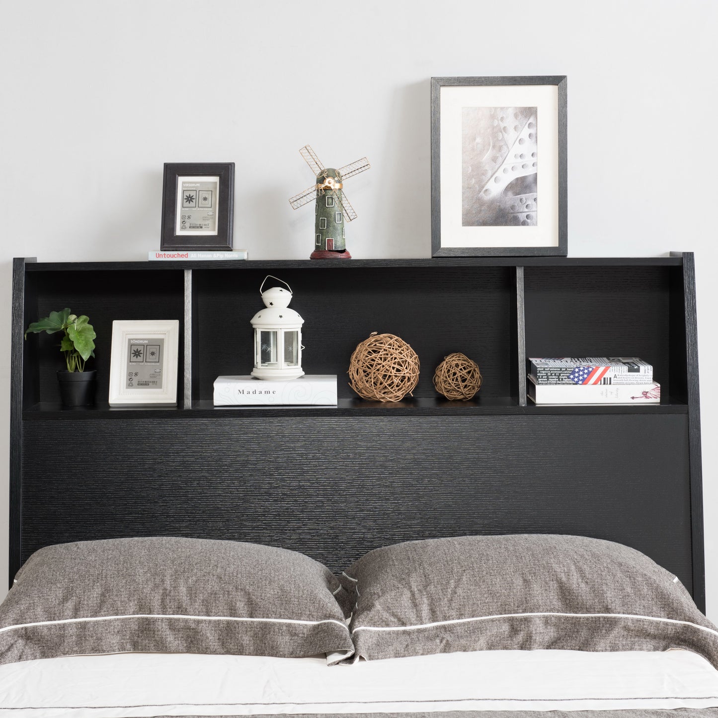Front-facing headboard detail of a contemporary cappuccino curvy platform storage bed with a bookcase headboard in a bedroom with accessories