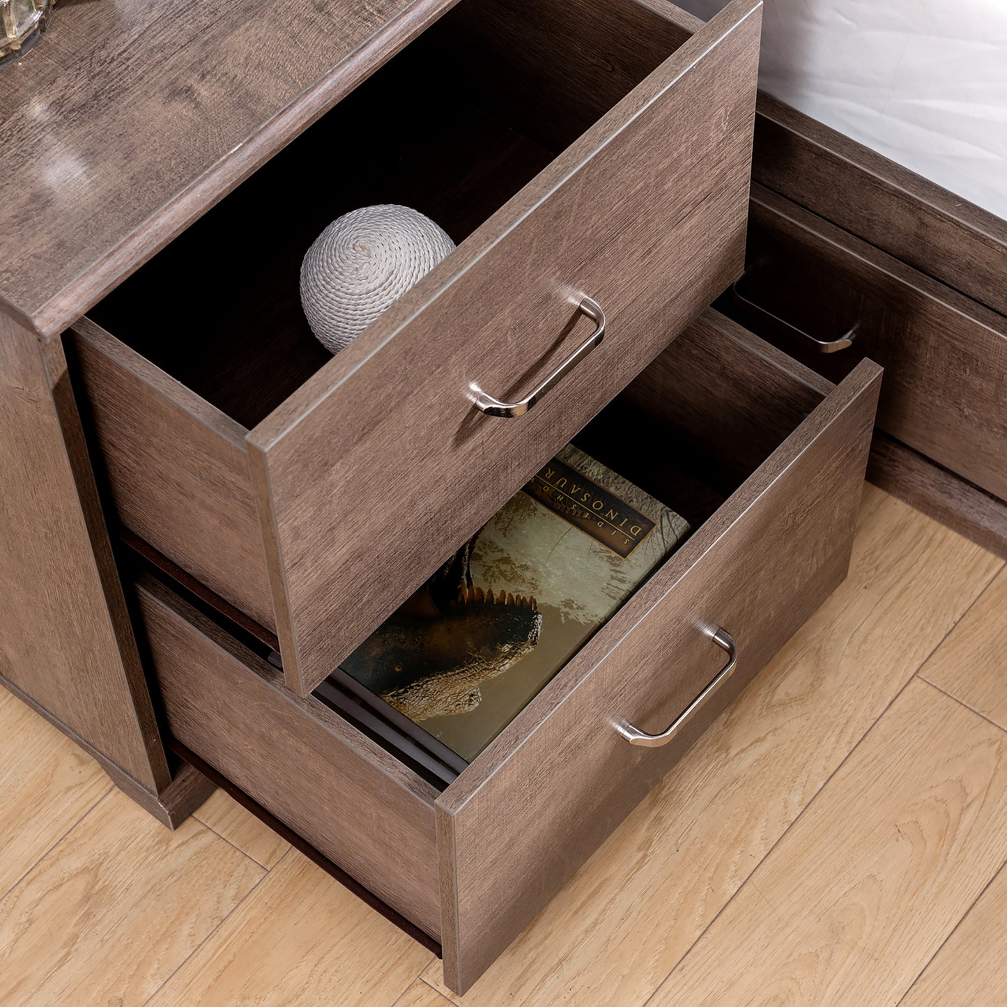 Right angled bird's eye close-up view of a two-piece contemporary walnut multi-storage bedroom set with nightstand drawers open in a bedroom with accessories