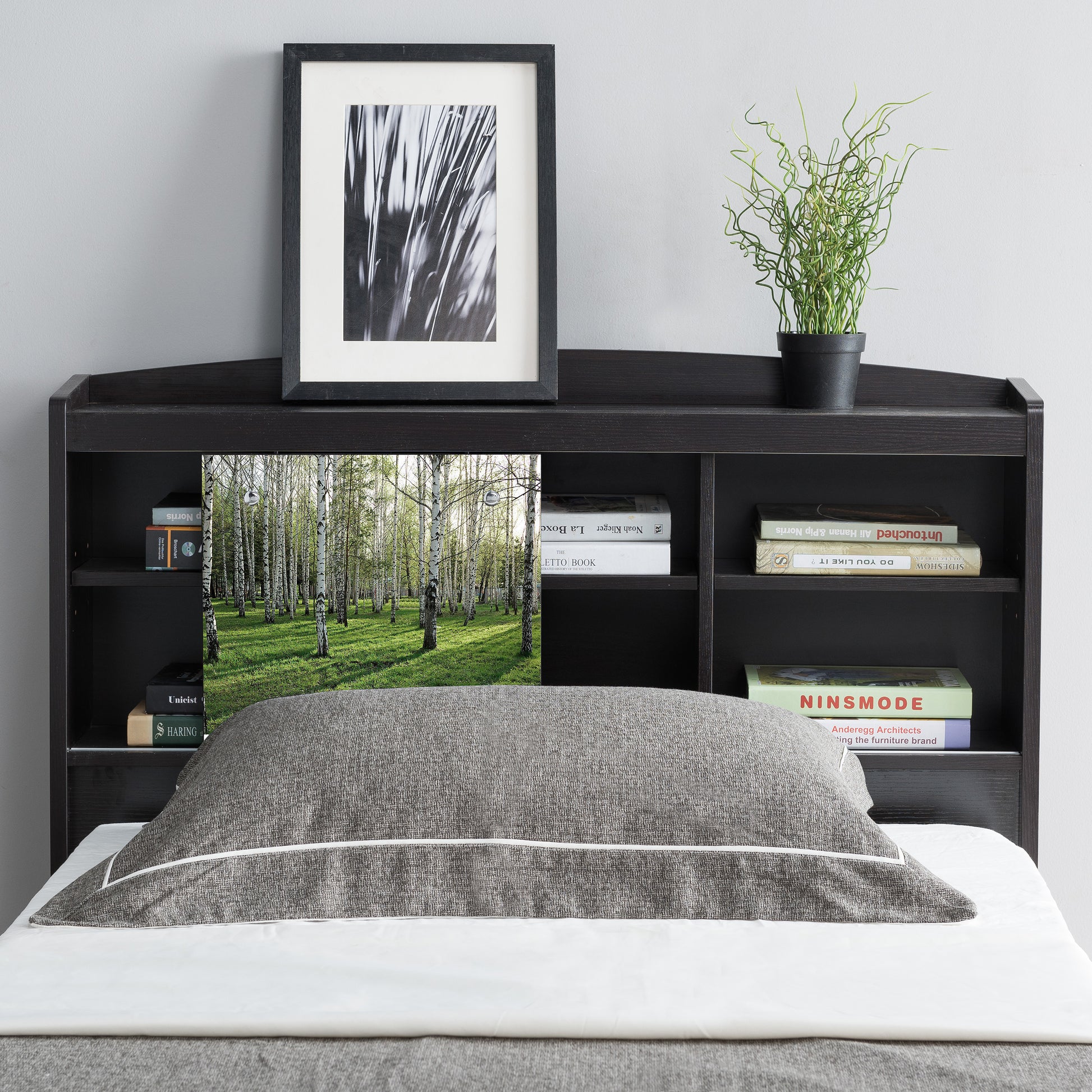 Front-facing contemporary cappuccino six-shelf bookcase headboard with sliding center panel to one side in a bedroom with accessories