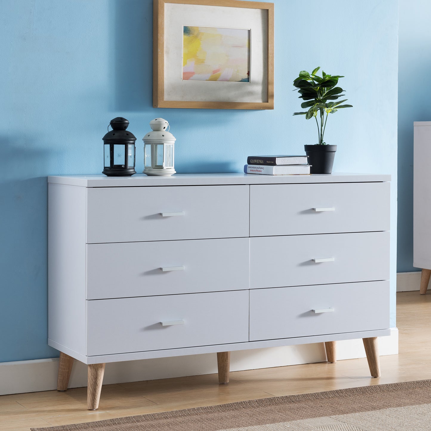 Right angled mid-century modern white six-drawer dresser in a bedroom with accessories