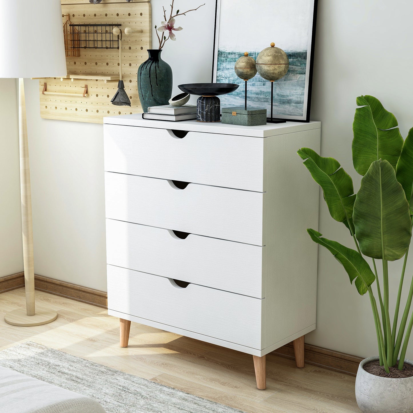 Left angled mid-century modern white four-drawer chest dresser in a bedroom with accessories