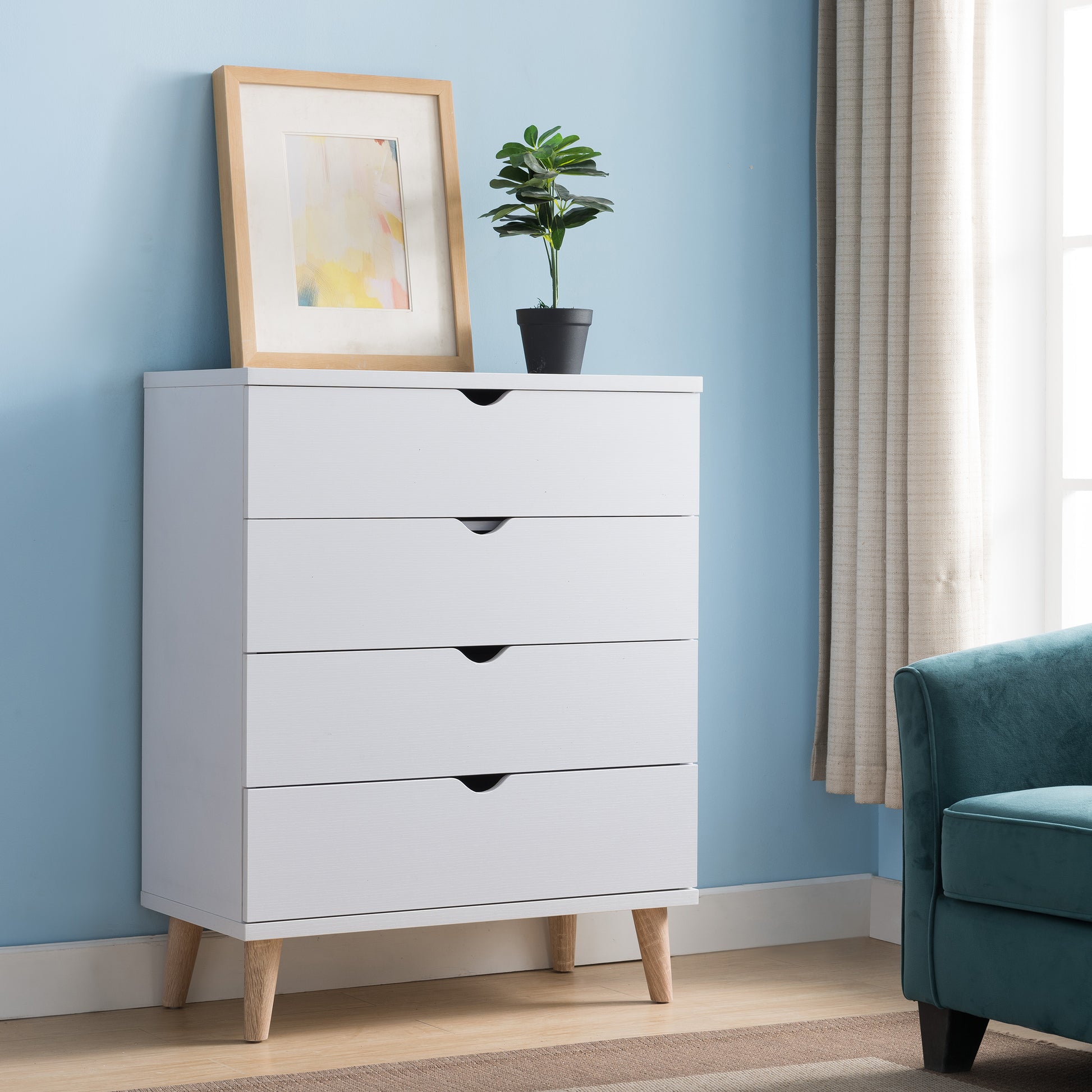 Right angled mid-century modern white four-drawer chest dresser in a bedroom with accessories