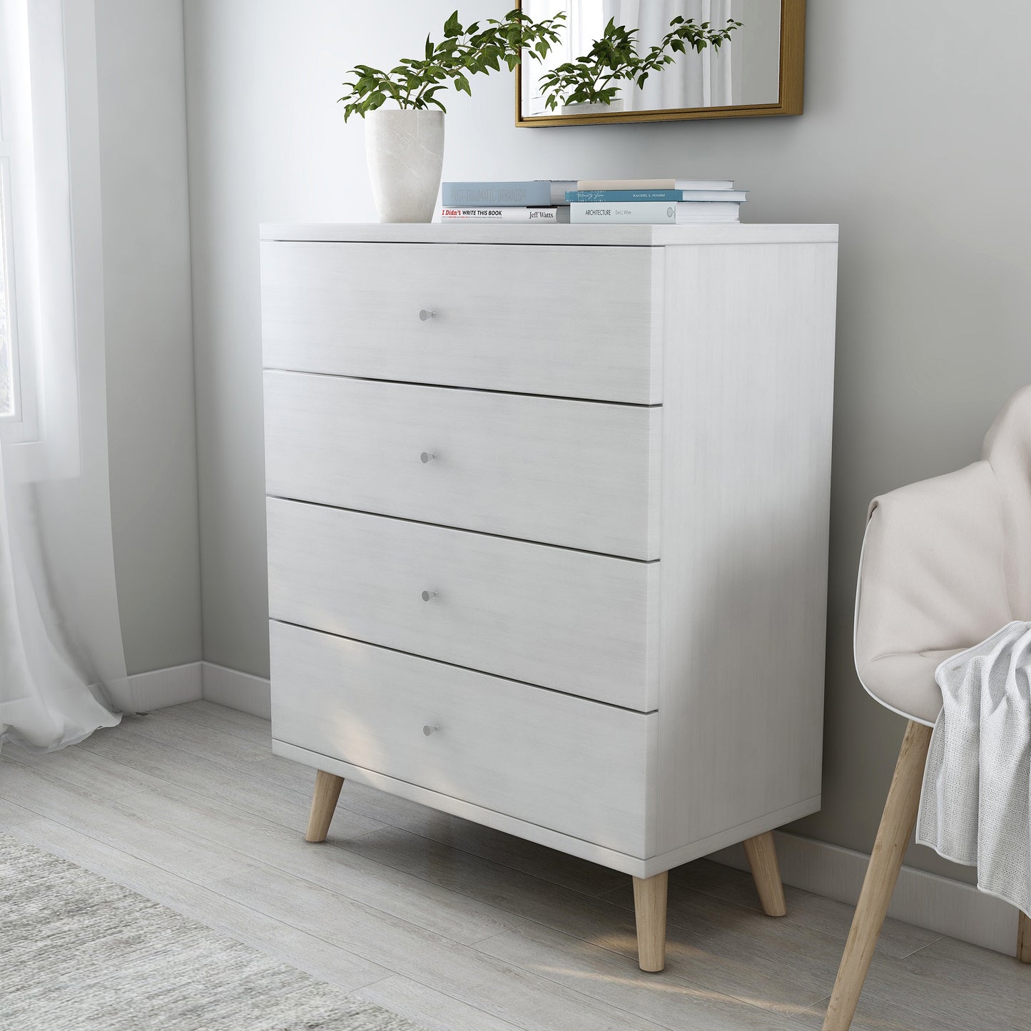 Left angled mid-century modern white four-drawer chest dresser in a bedroom with accessories