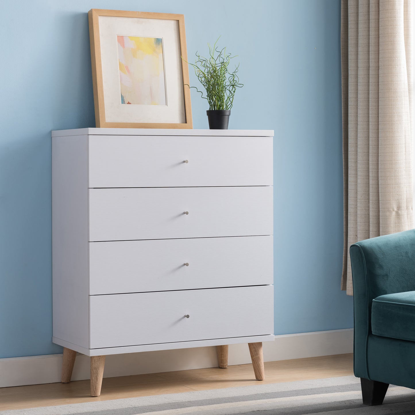 Right angled mid-century modern white four-drawer chest dresser in a bedroom with accessories